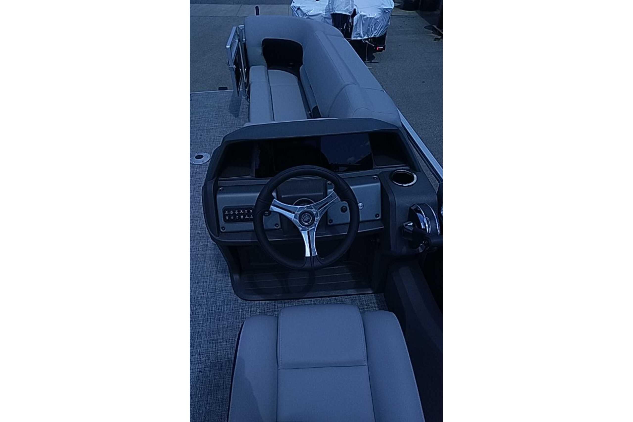 2026 Sun Tracker SportFish 22 DLX boat interior with steering wheel and seating.