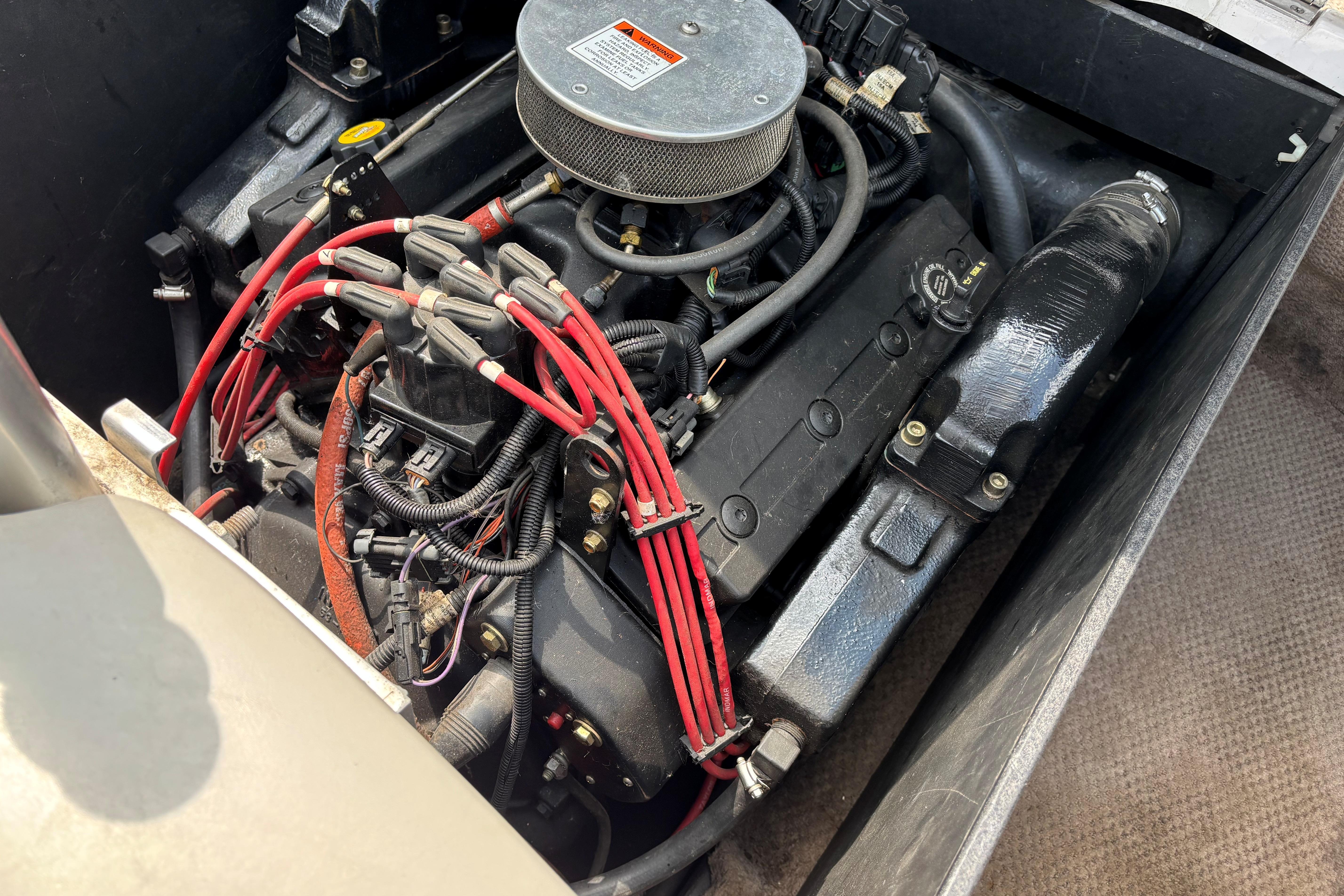 Engine of a 1999 MasterCraft 205 PRO STAR boat with red ignition wires.