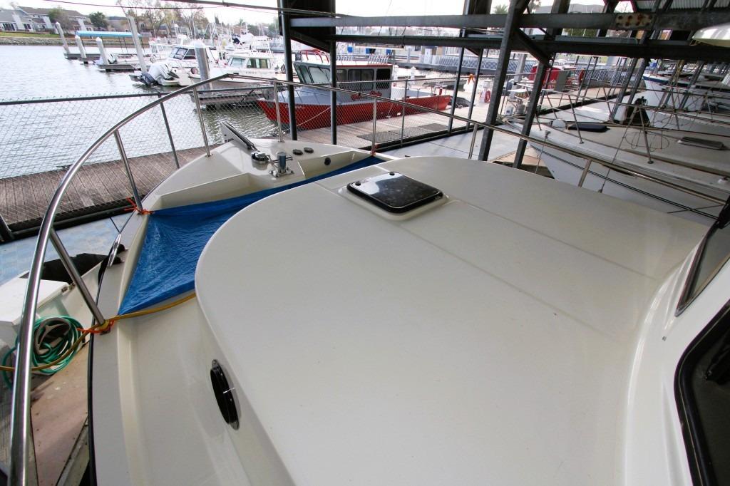 2002 Nordic Tug 37 docked in marina, showcasing deck and railing.