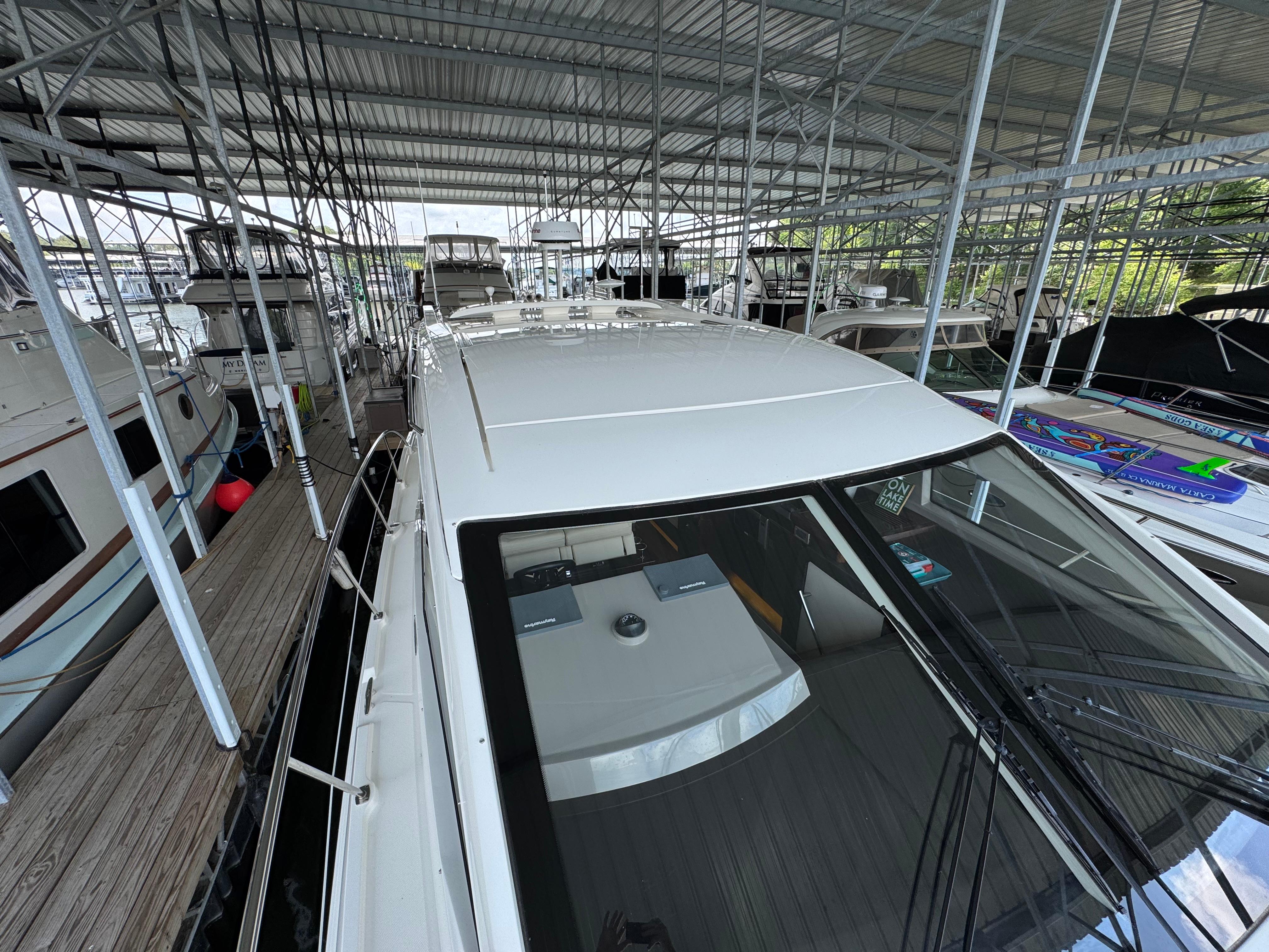 2017 Sea Ray Sundancer 400 docked in a covered marina, surrounded by other boats.