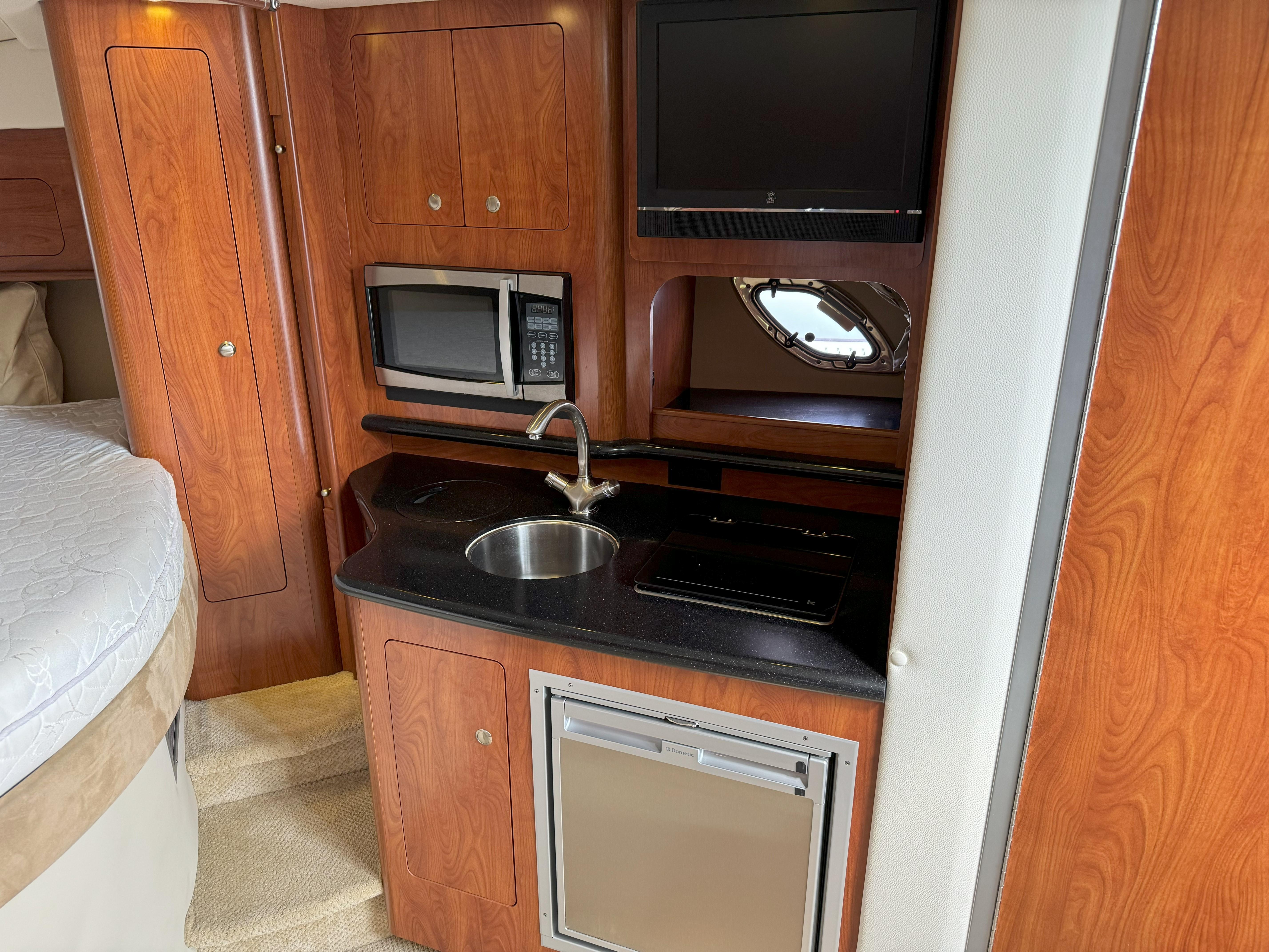 Interior of 2010 Rinker 310 Express Cruiser with kitchenette and sleeping area.