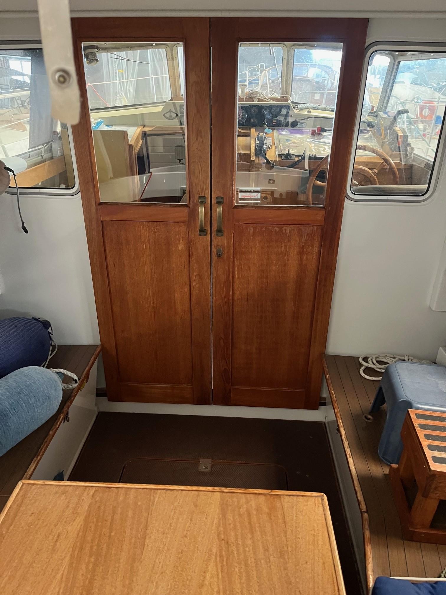 Interior of 1980 LM 32 boat with wooden doors and seating area.