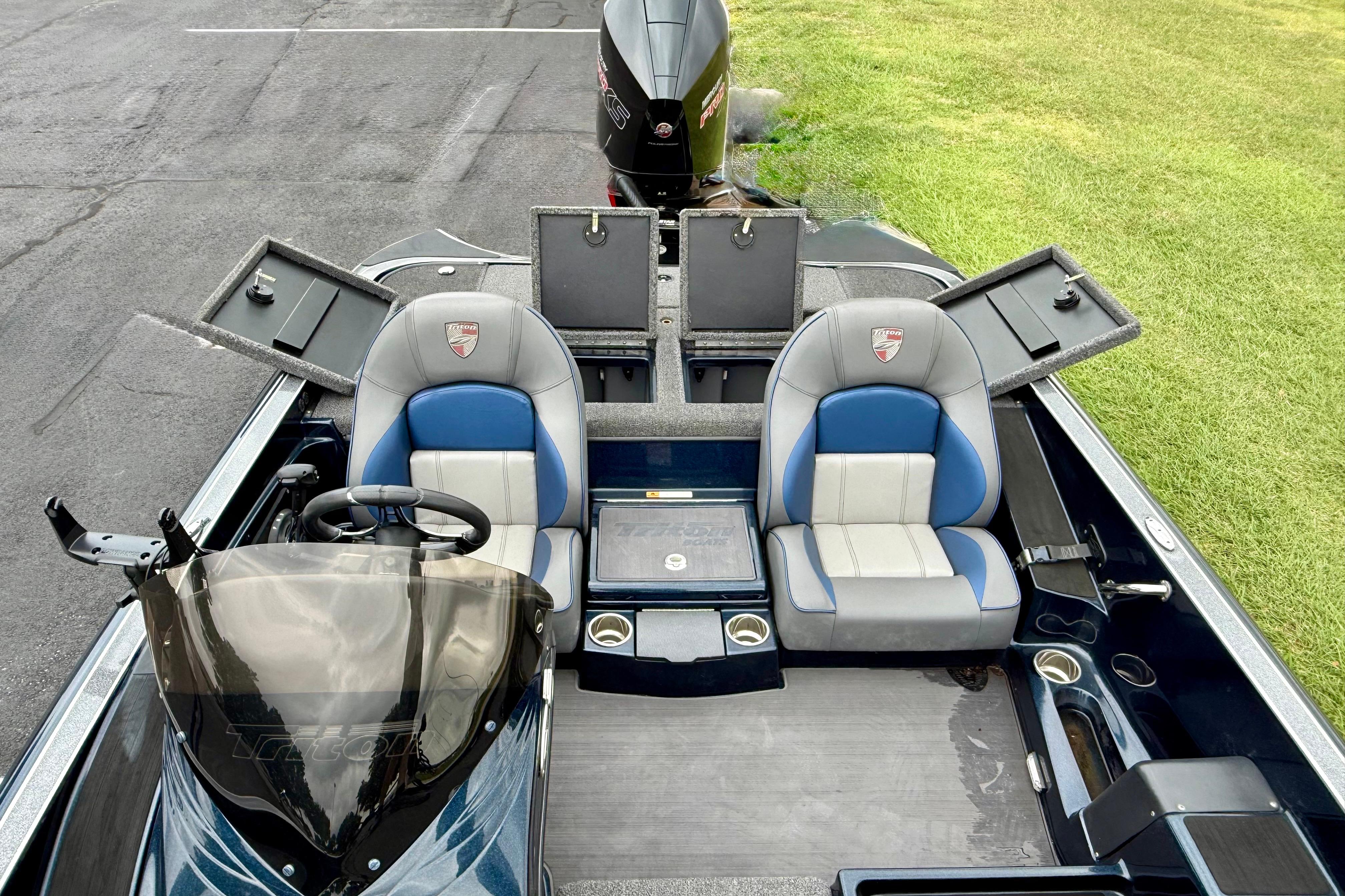 2023 Triton 18 TrX boat interior with dual seats and storage compartments open.