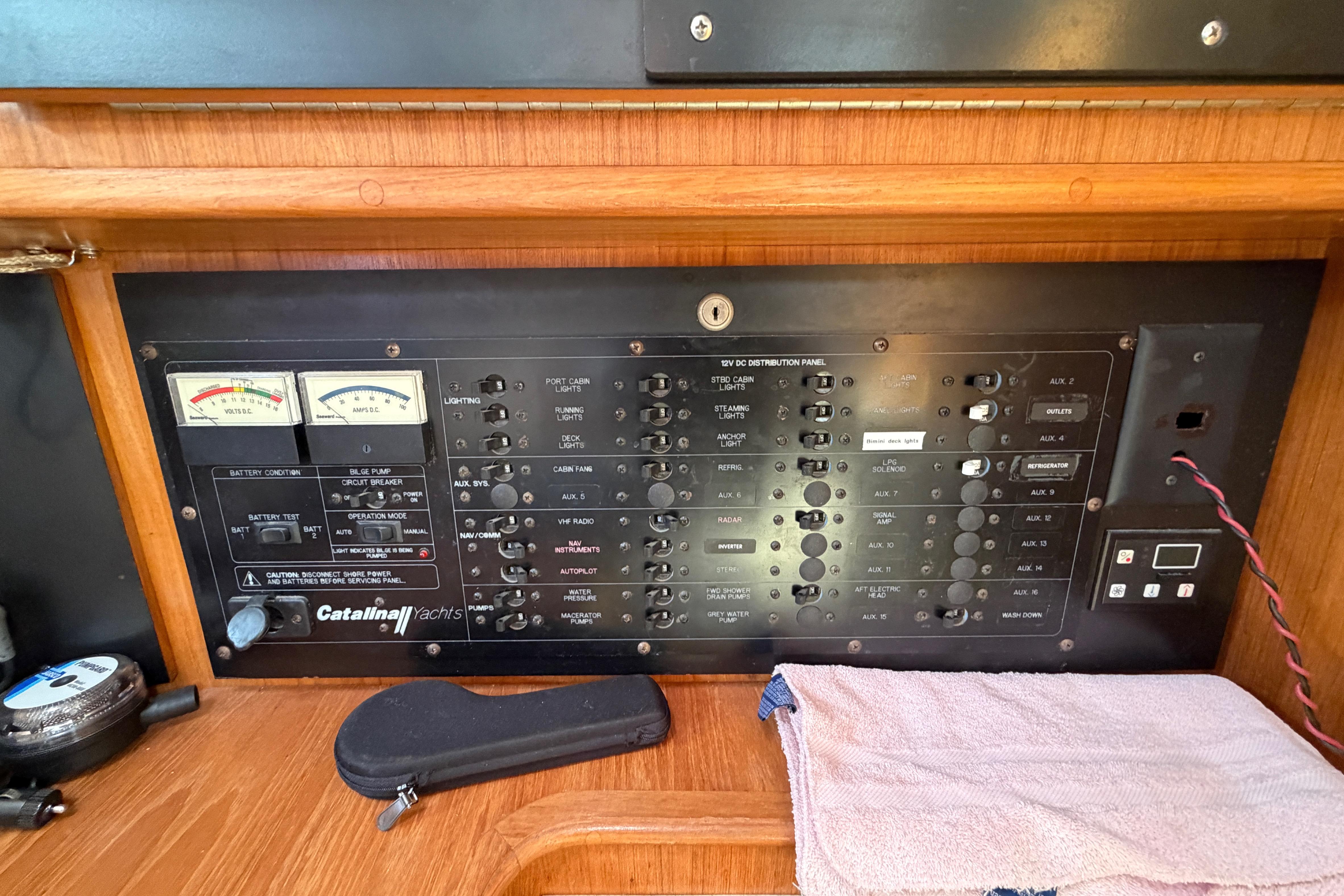 Electrical control panel of a 2002 Catalina 470 yacht with various switches and gauges.