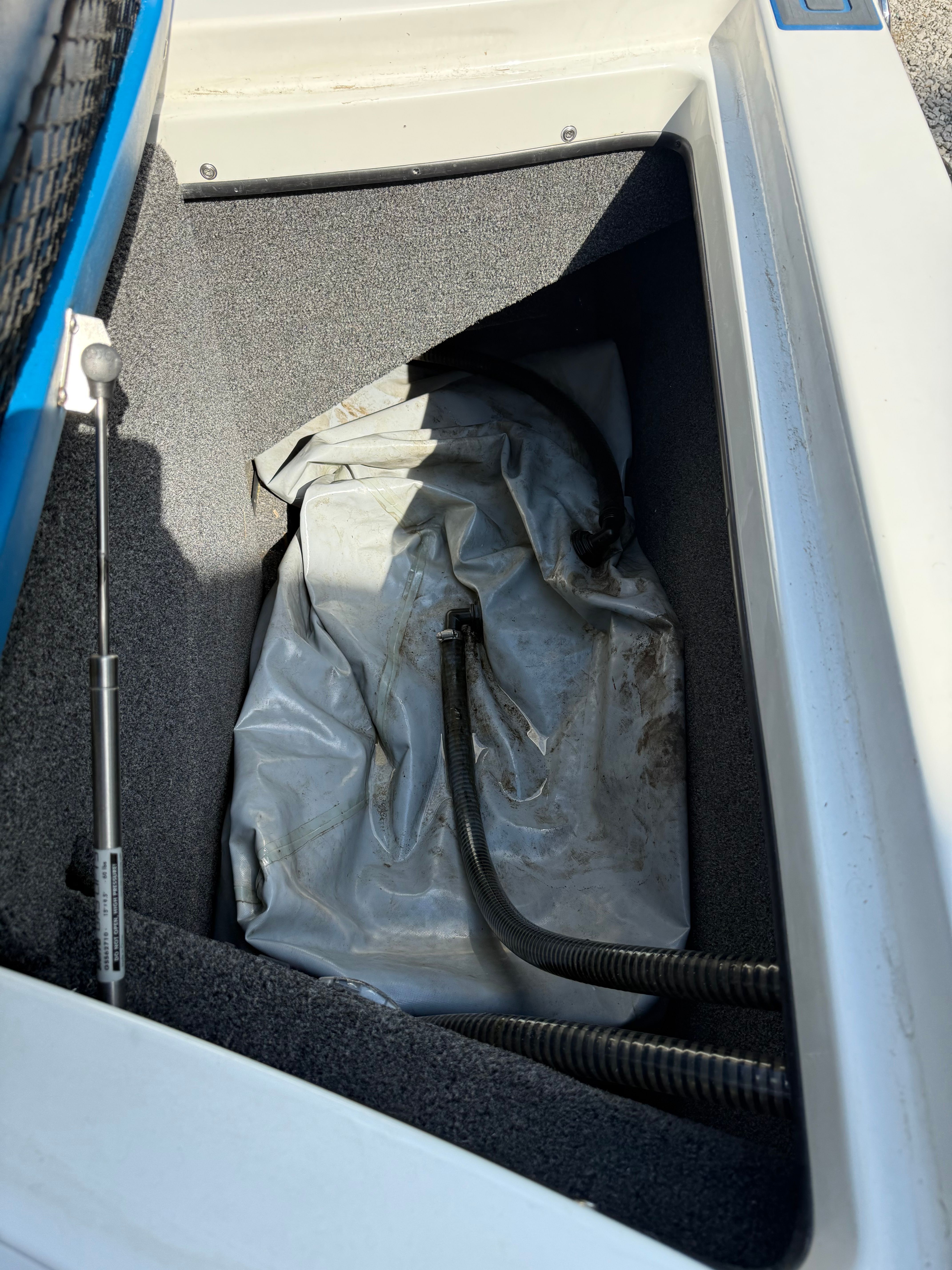 Interior of a 2012 Custom Z3 with storage compartment and hoses.