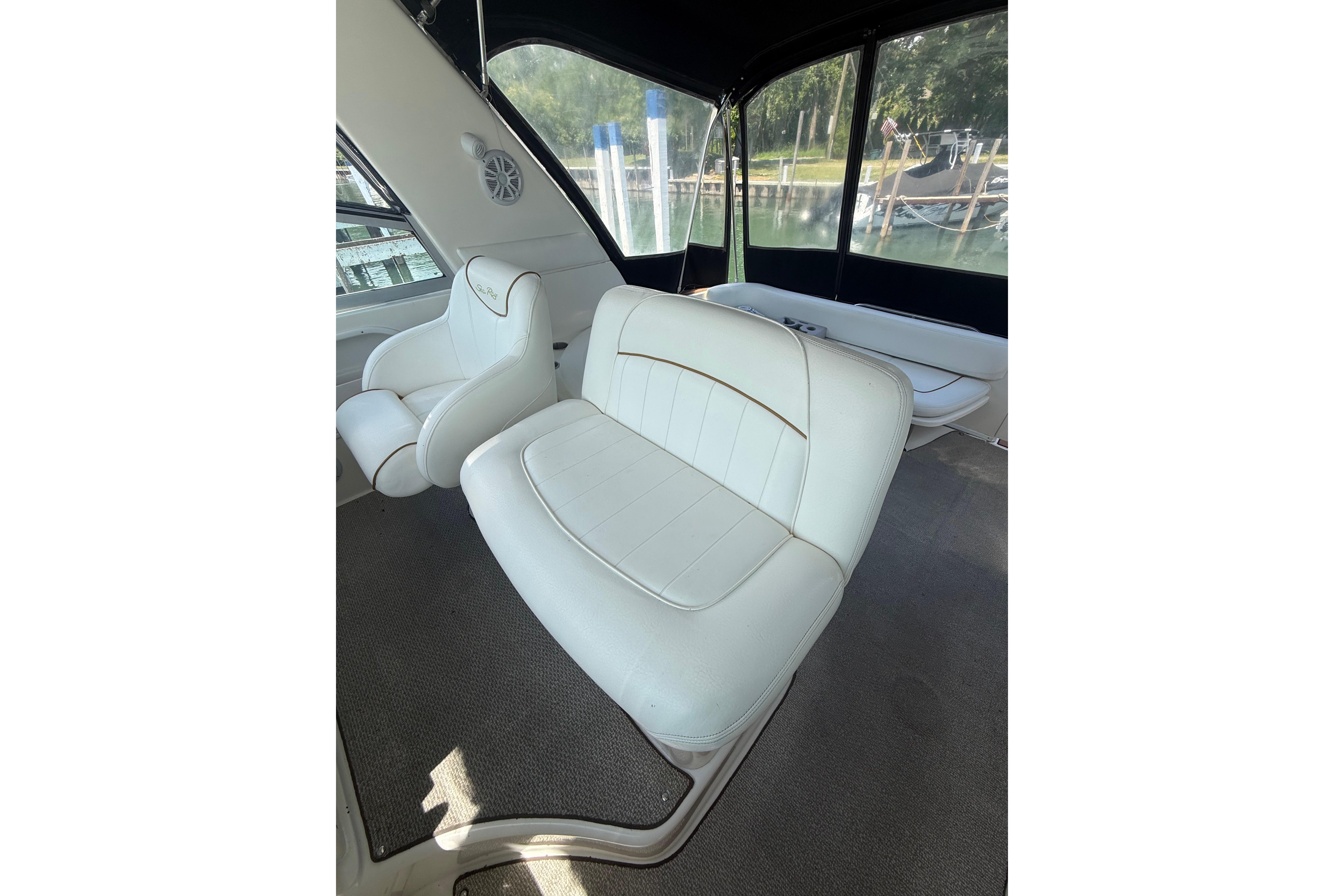 Interior seating of a 1999 Sea Ray Sundancer 310 boat, featuring white upholstery.