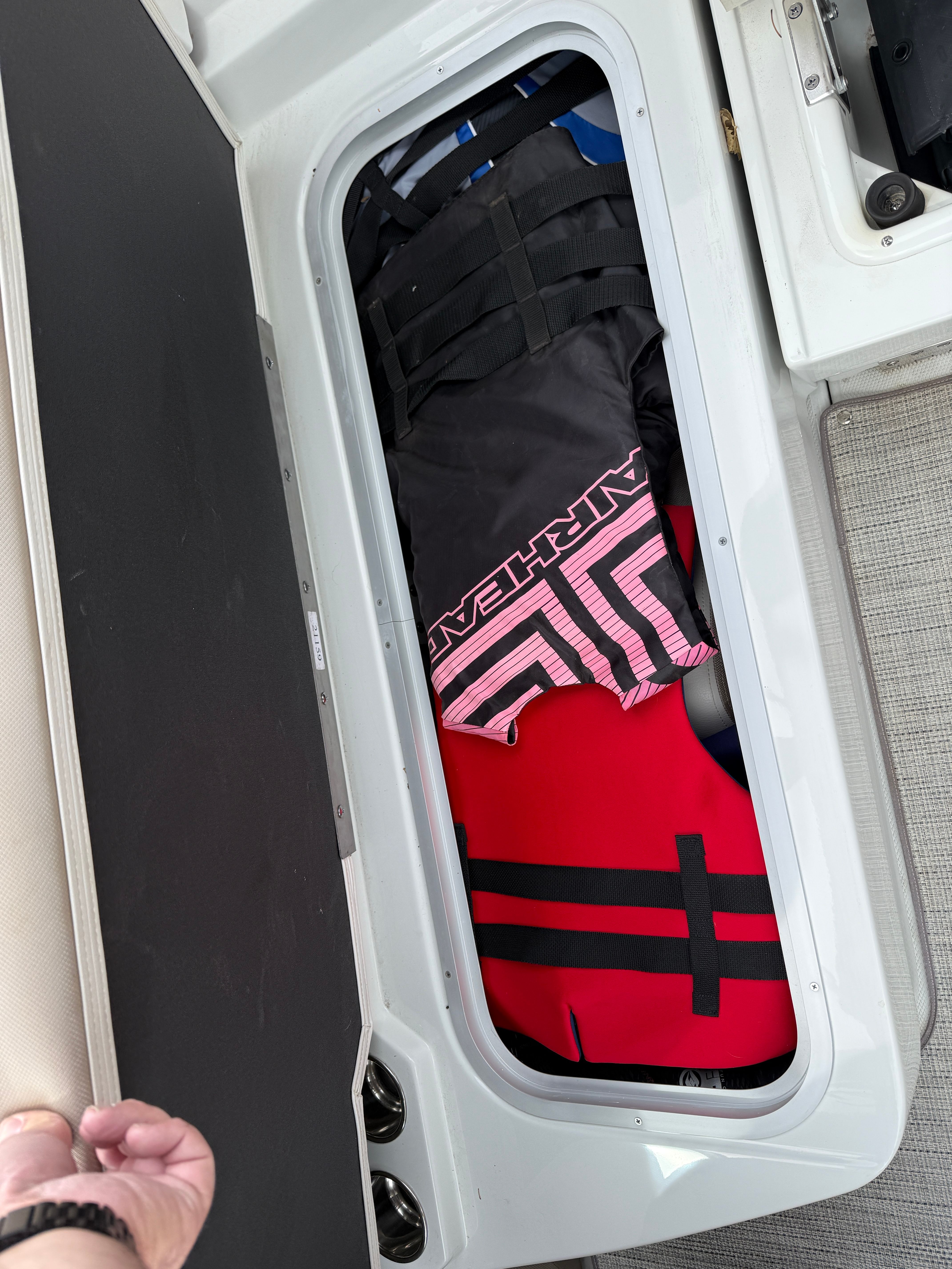 Storage compartment in Crownline 235 SS boat with life jackets.