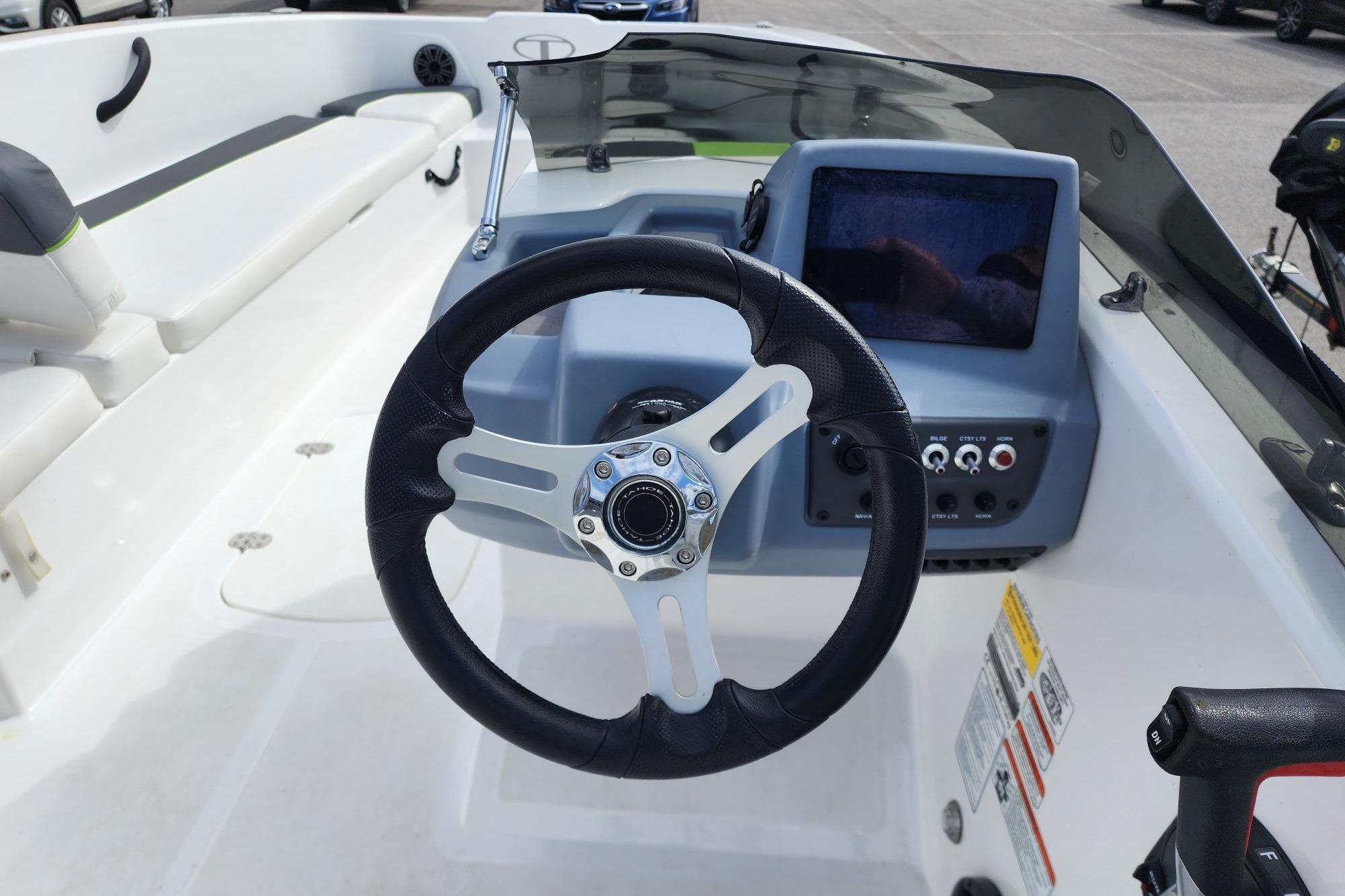 Steering wheel and dashboard of 2023 Tahoe T18 boat, featuring modern controls and seating.