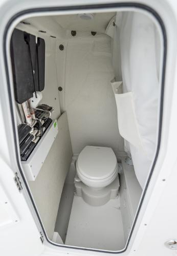 2025 Sea Hunt Ultra 235 SE boat interior with compact marine toilet.