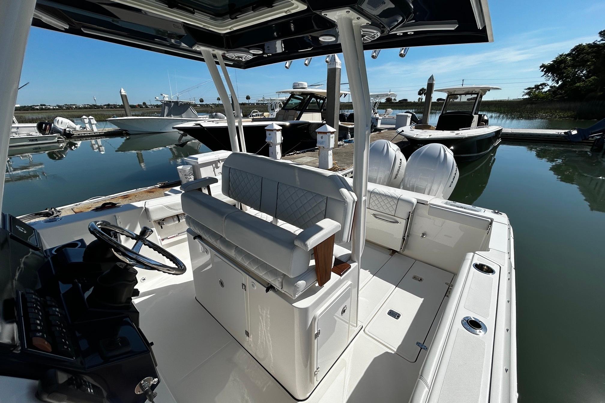 2024 Pursuit S 288 Sport boat docked at marina, showcasing sleek interior and helm.