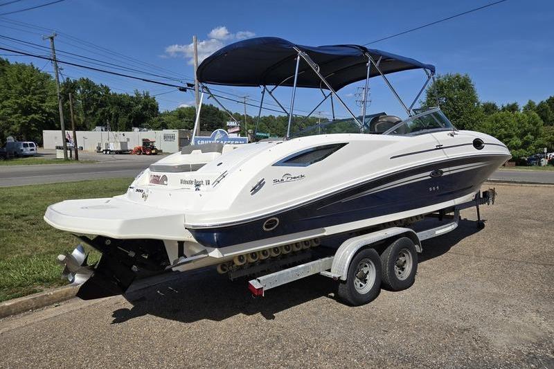 2011 Sea Ray 300 Sundeck boat on trailer, parked outdoors under blue sky.