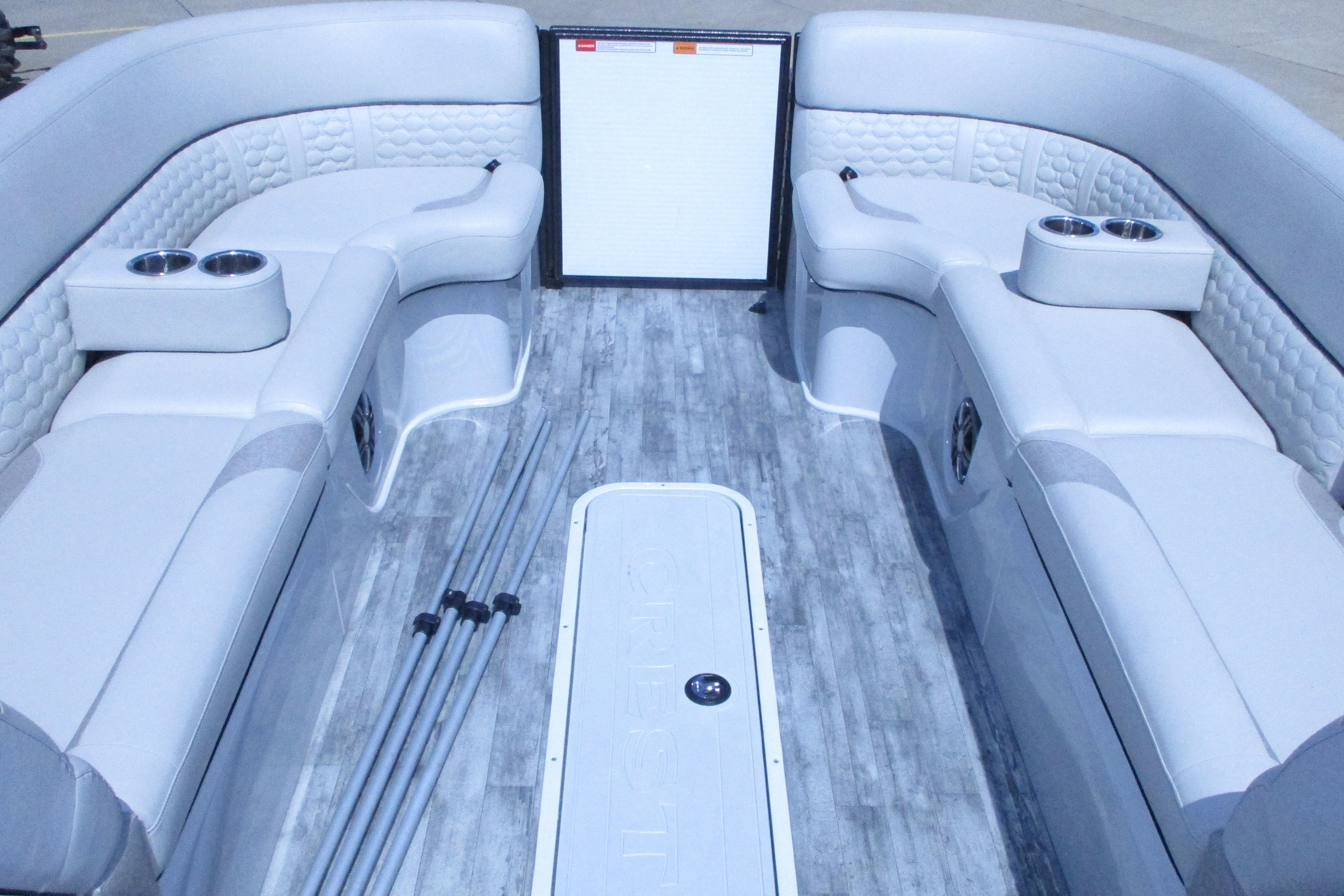 Interior of 2021 Crest Caribbean LX 250 SLS pontoon boat with luxurious seating and cup holders.