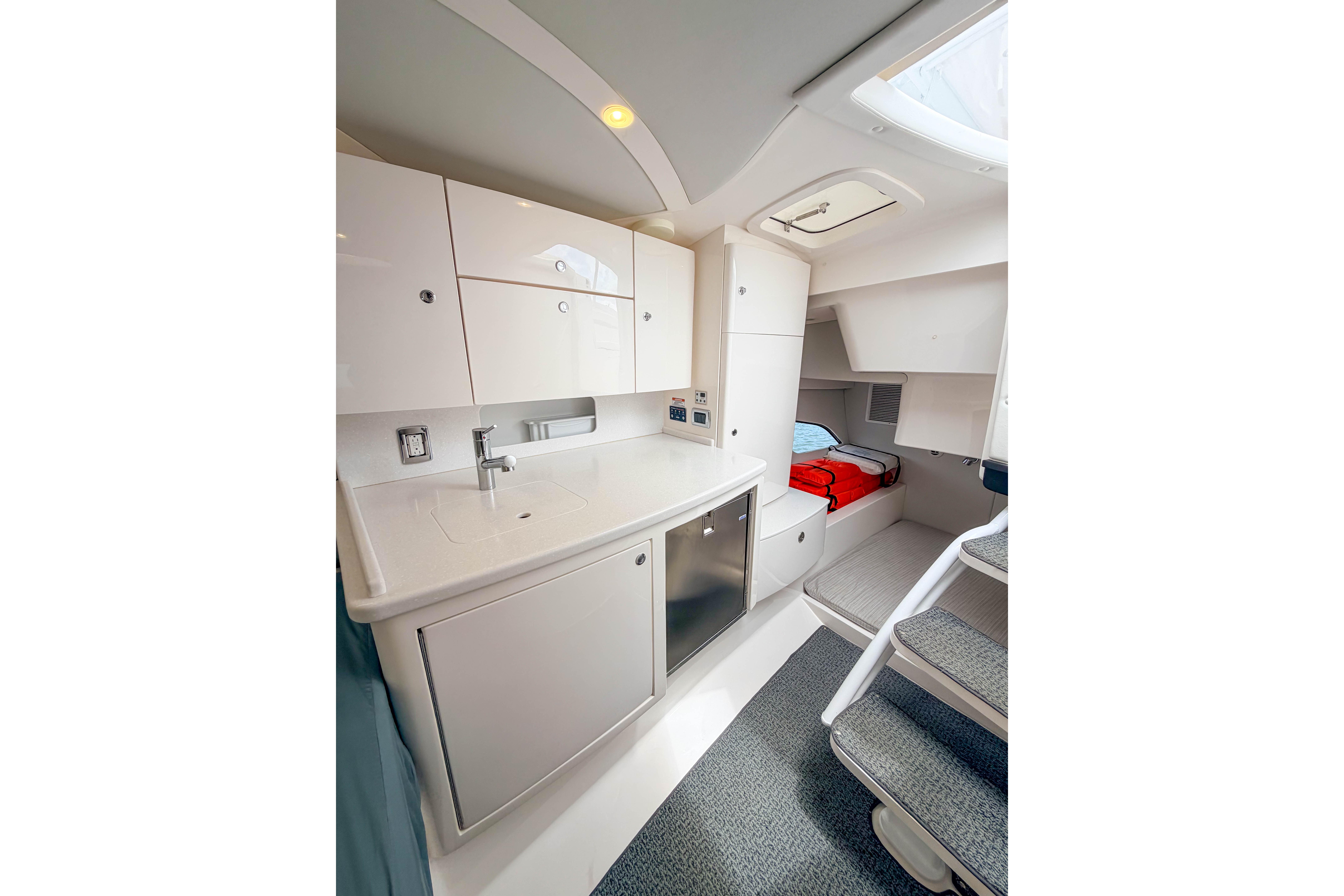 Modern interior of 2021 Intrepid 409 Valor boat with kitchenette and sleeping area.