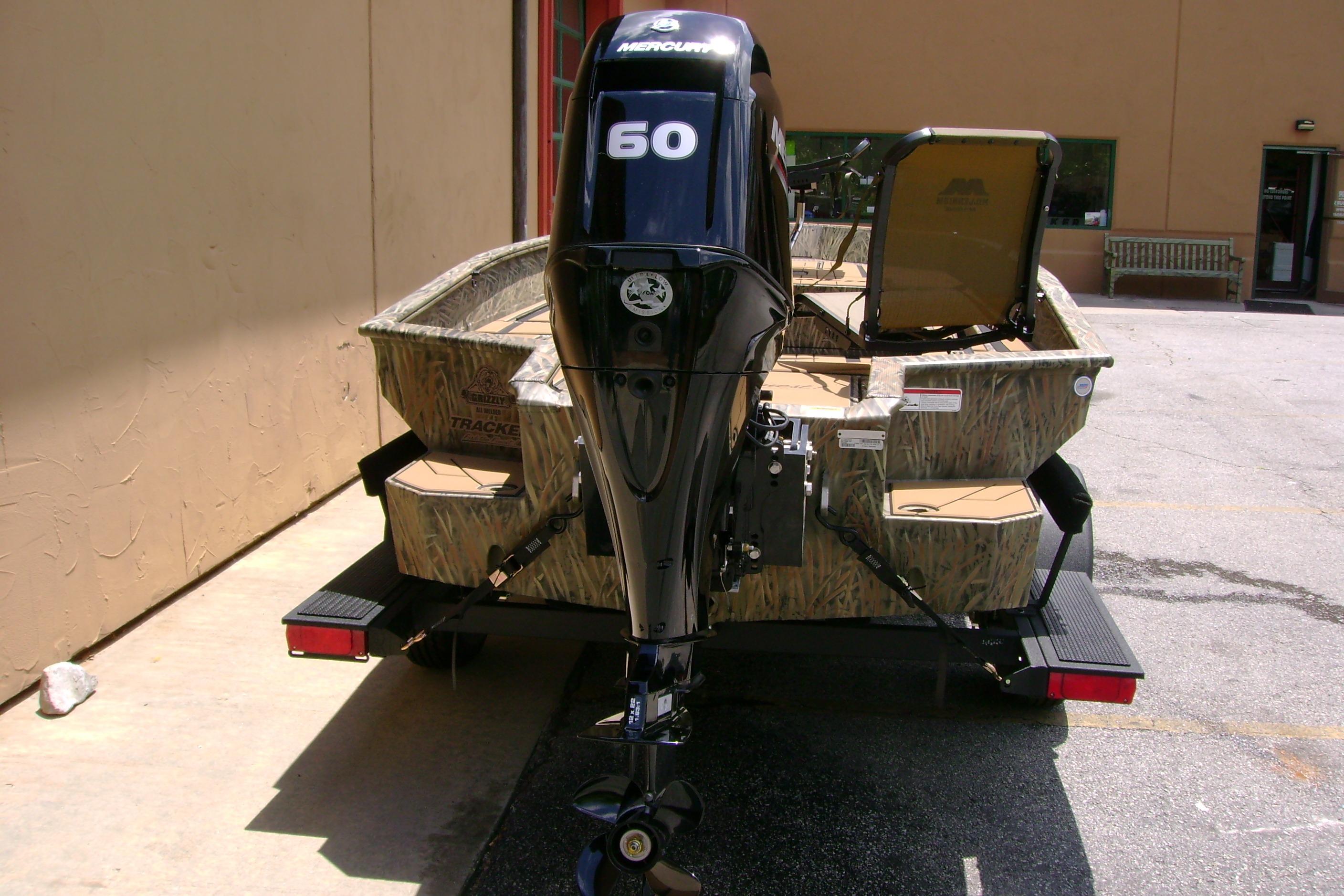 2026 Tracker Grizzly 1756 T Marsh boat with Mercury 60 outboard motor, parked outdoors.