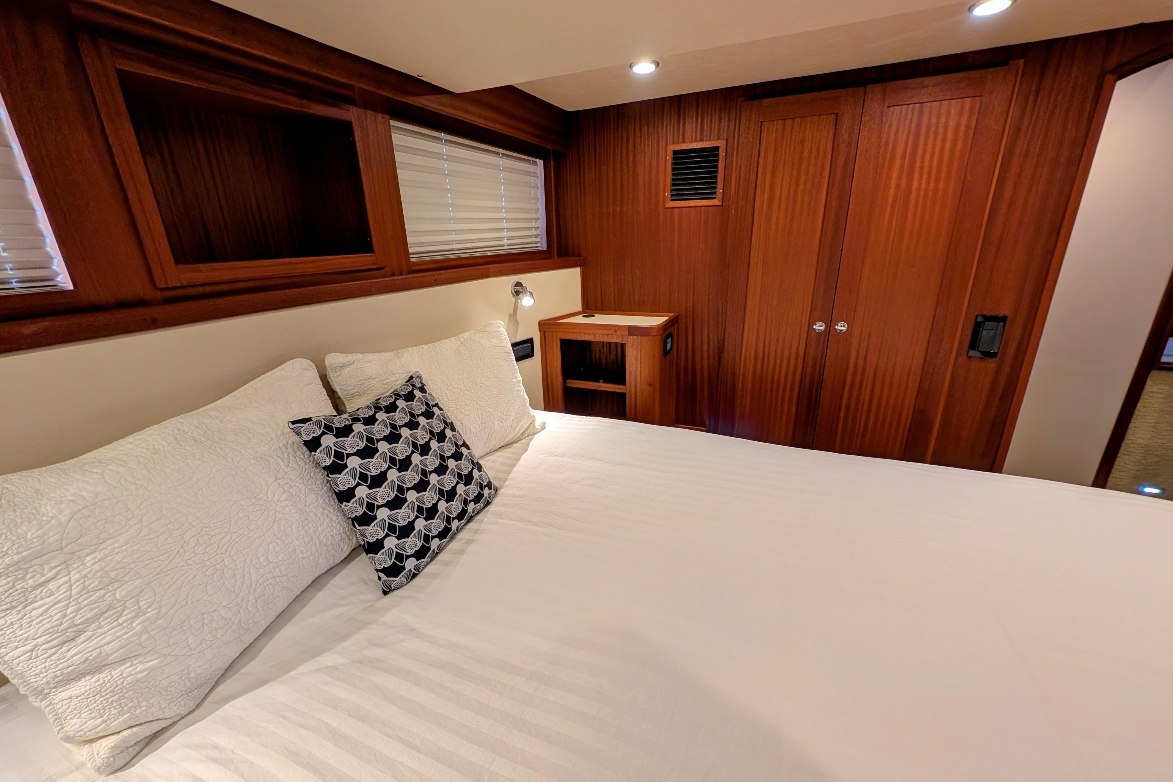 Luxurious cabin interior of 2015 American Tug 435 with wood paneling and cozy bedding.