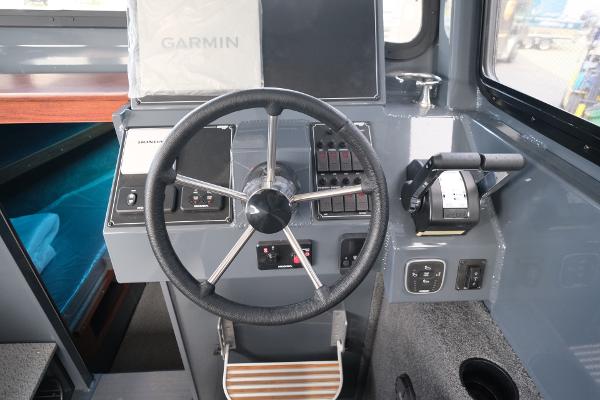 2024 Hewescraft 250 Explorer boat cockpit with steering wheel and Garmin navigation system.