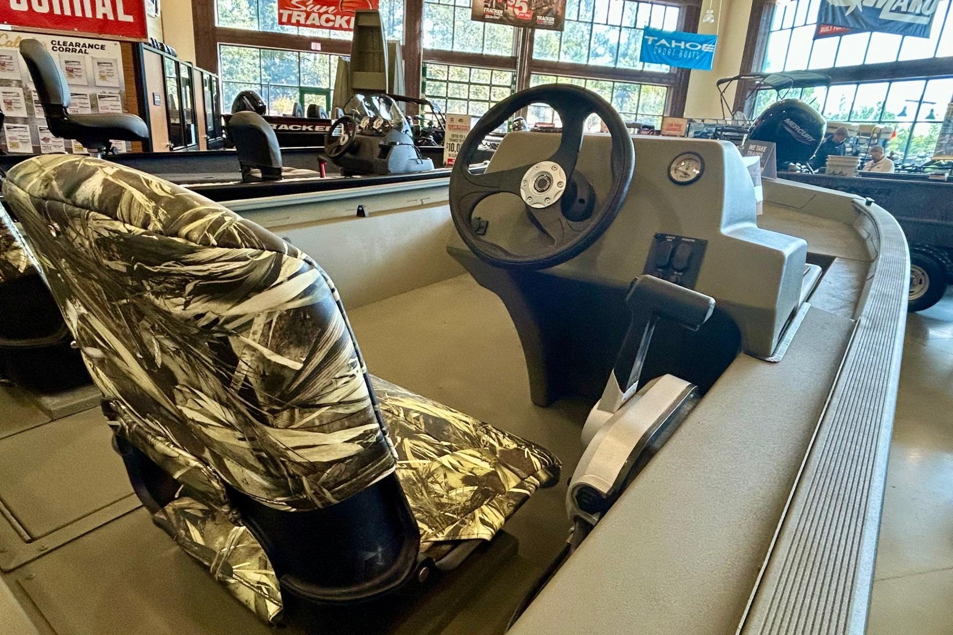 2026 Tracker Grizzly 1754 SC boat interior with camo seat and steering console.