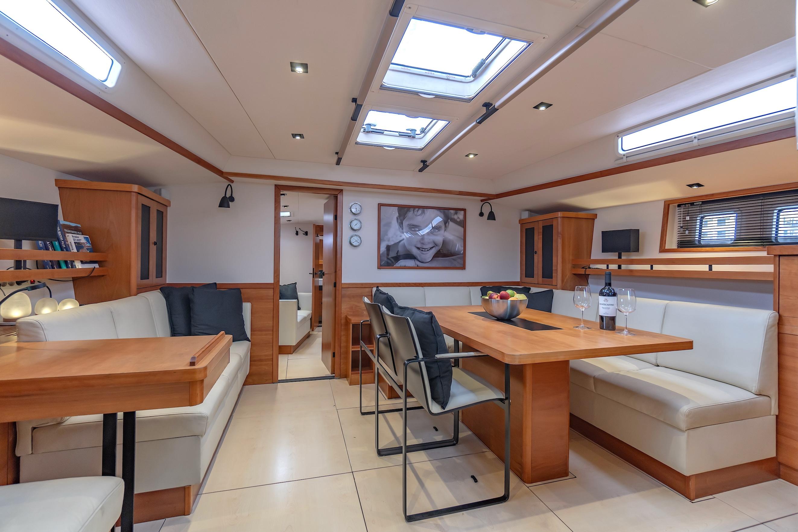 Luxurious interior of 2009 Hanse 630e yacht with elegant seating and dining area.