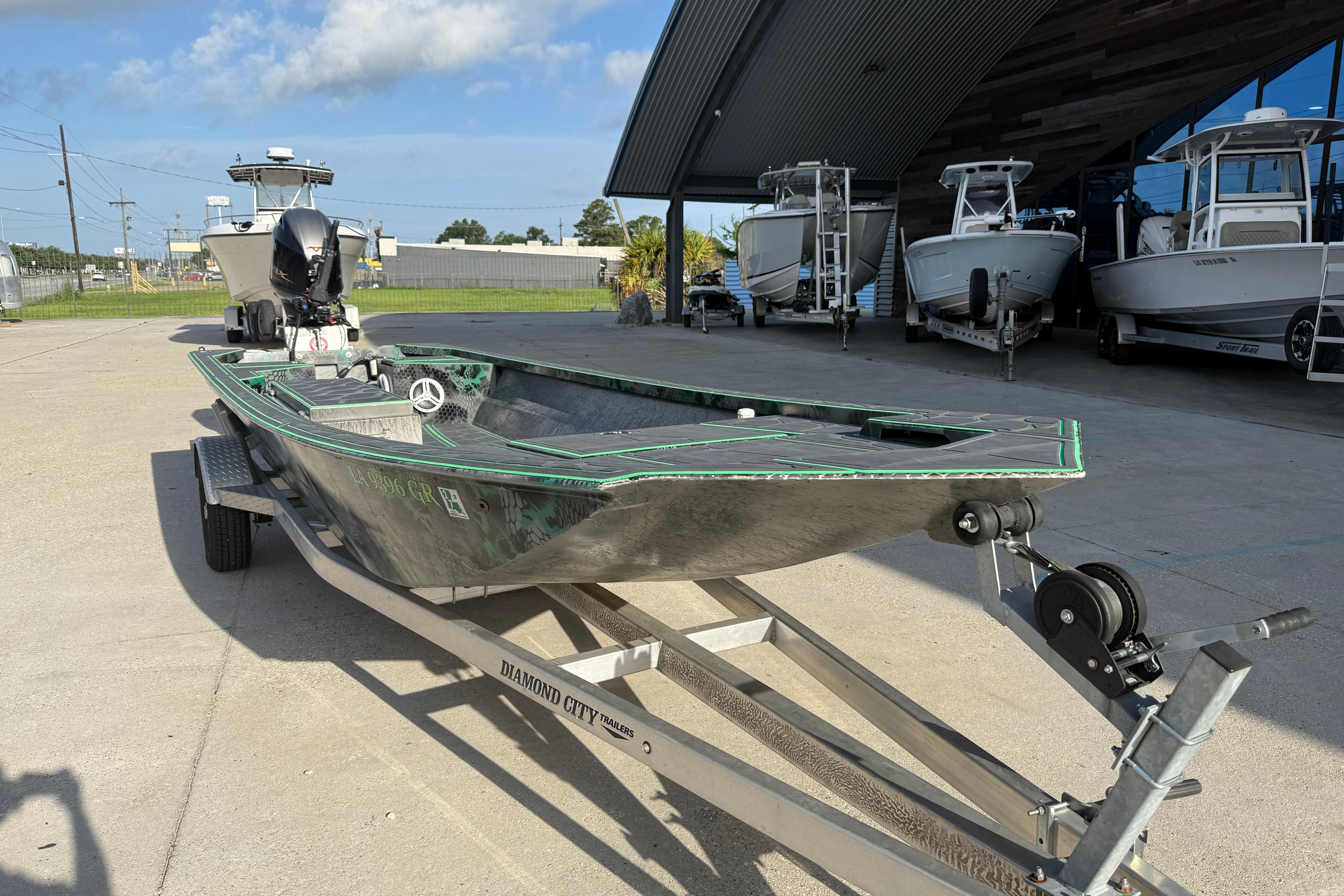 Custom Rene Gros 20x48 boat on trailer, 2024 model, parked near other boats.