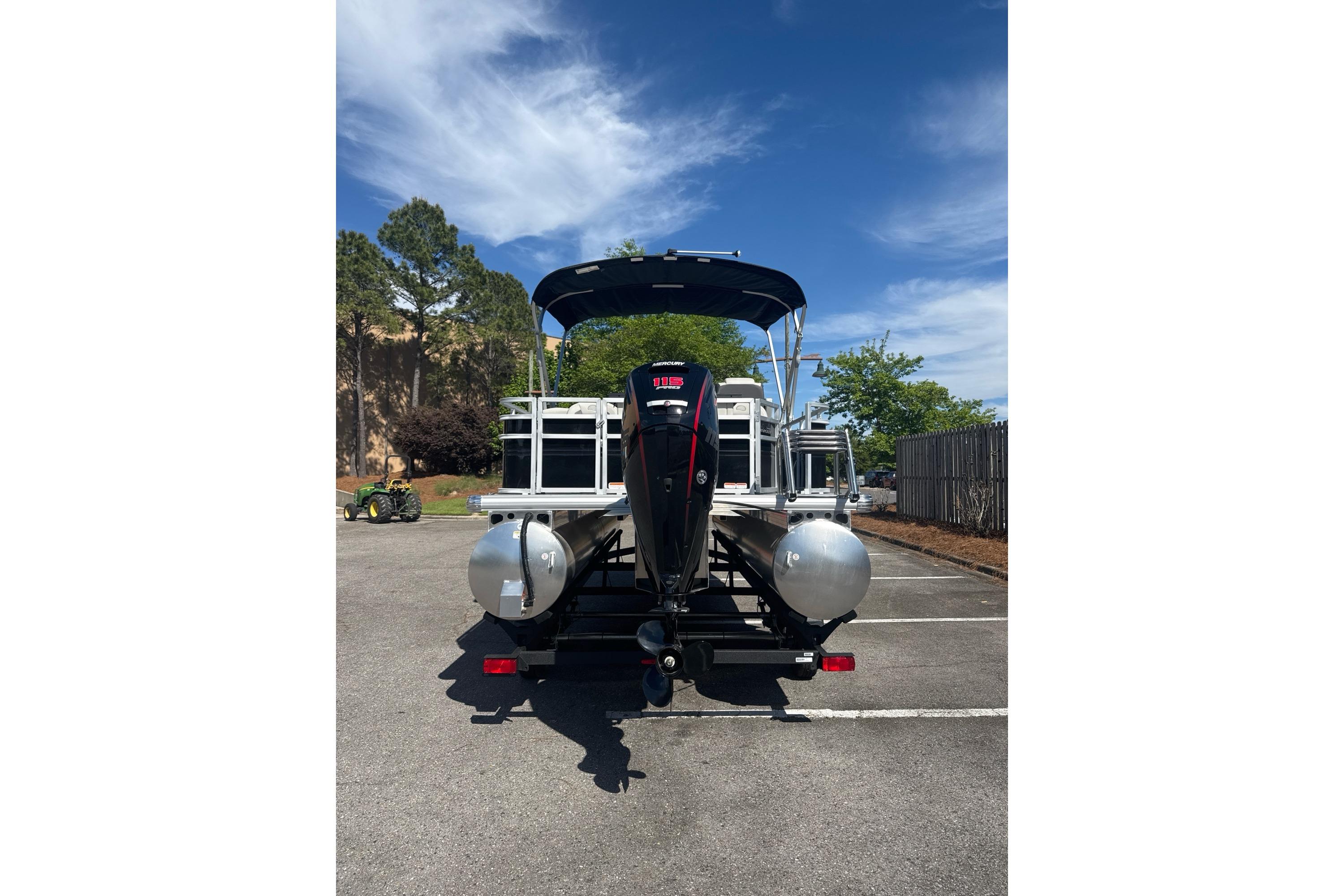 2026 Sun Tracker Fishin' Barge 20 DLX pontoon boat parked outdoors.