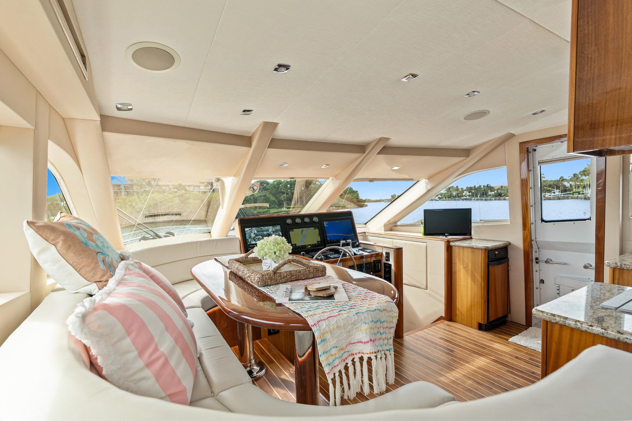 Luxurious interior of 2008 Hatteras 64 Motor Yacht with elegant seating and navigation equipment.