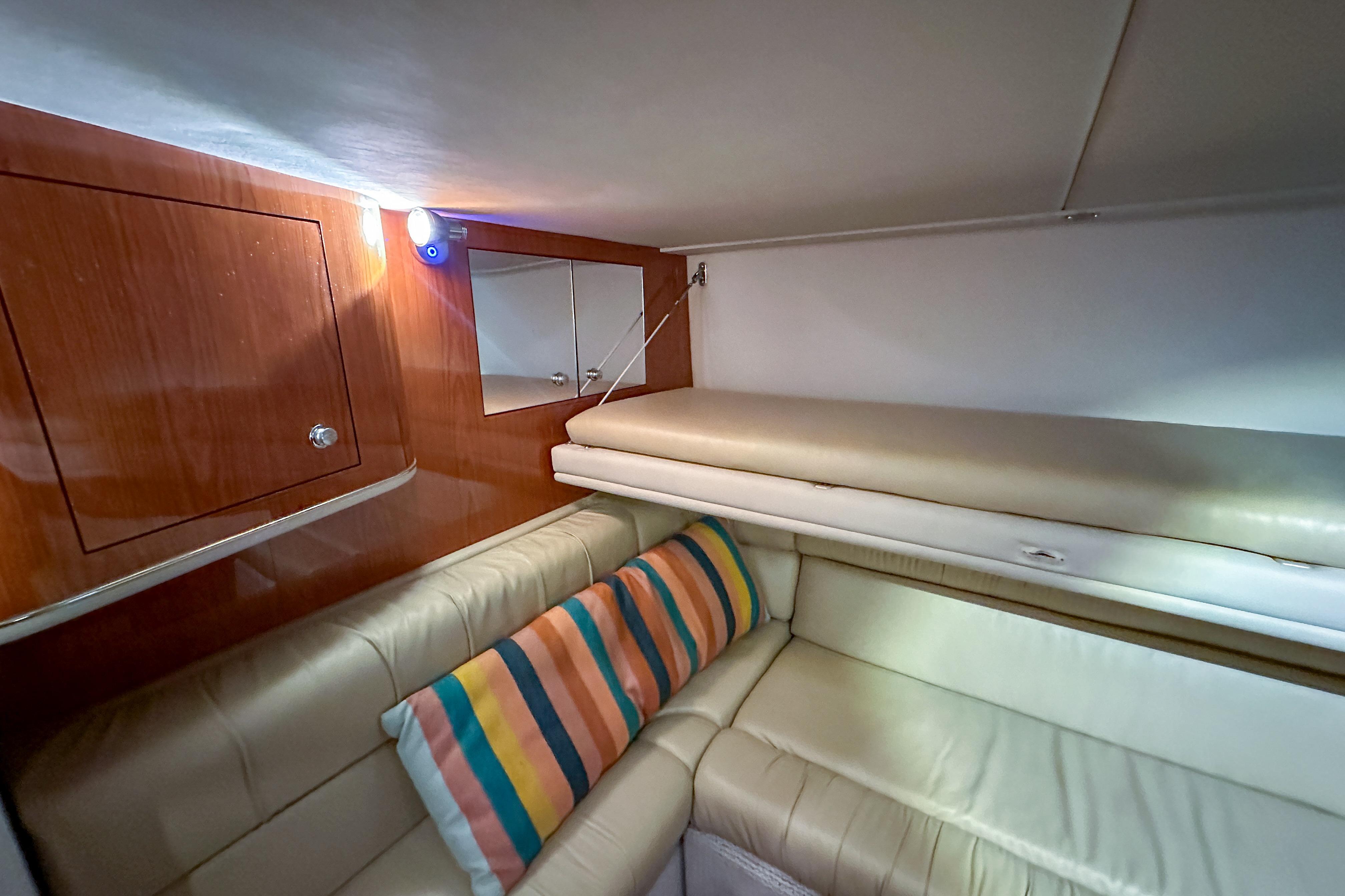 Luxurious interior of 2001 Sea Ray 410 Sundancer with leather seating and striped pillow.
