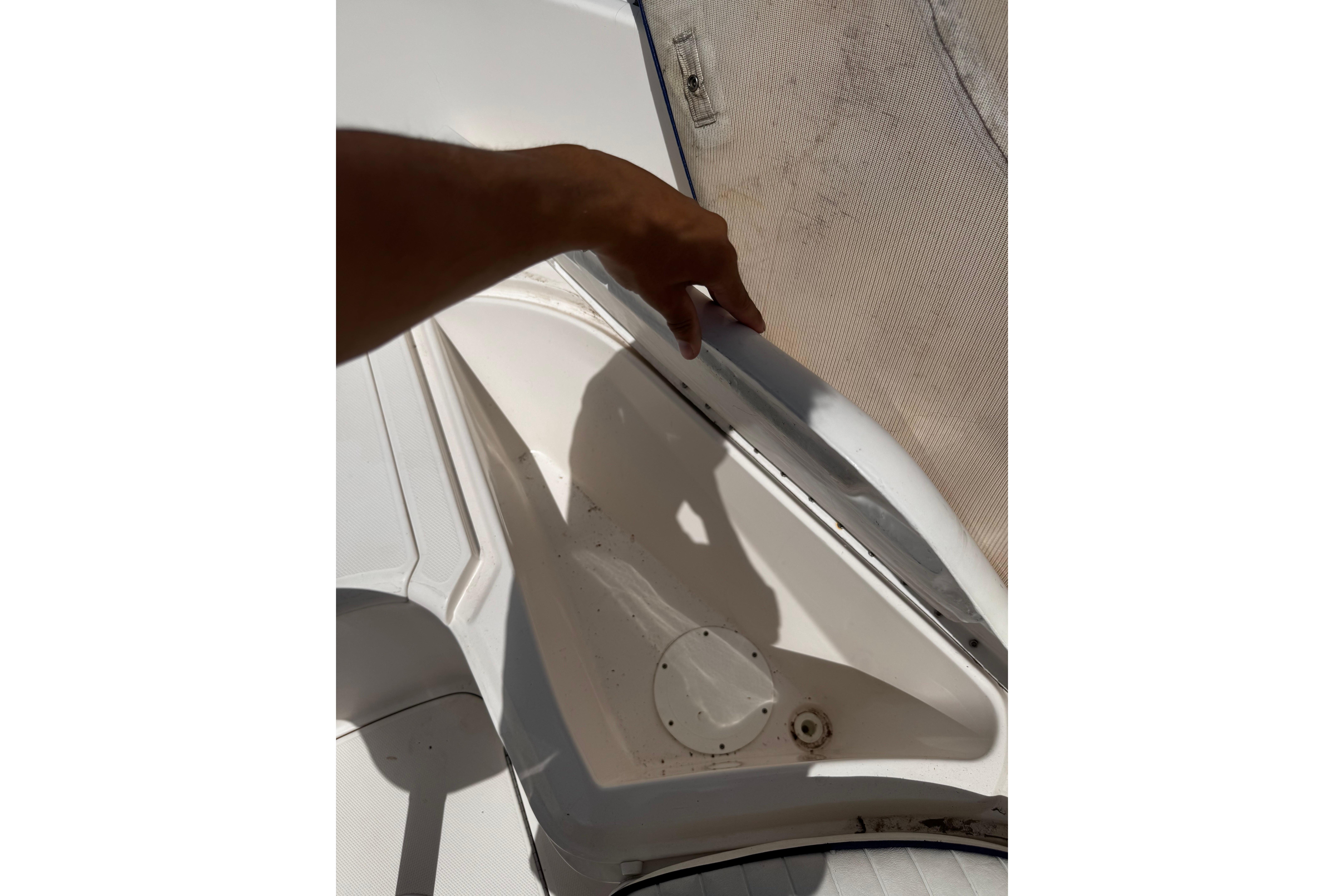 2003 Palm Beach 2200 Dual Console boat interior detail with hand pointing.