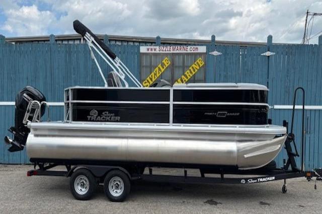 2026 Sun Tracker Party Barge 20 DLX pontoon boat on trailer, parked outdoors.