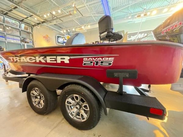 2025 Tracker Savage 215 boat on trailer in showroom, red exterior, dual axles.