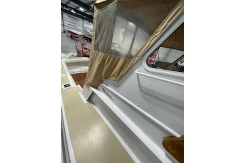 1964 Striker Model 120 boat interior with beige canopy in a storage facility.