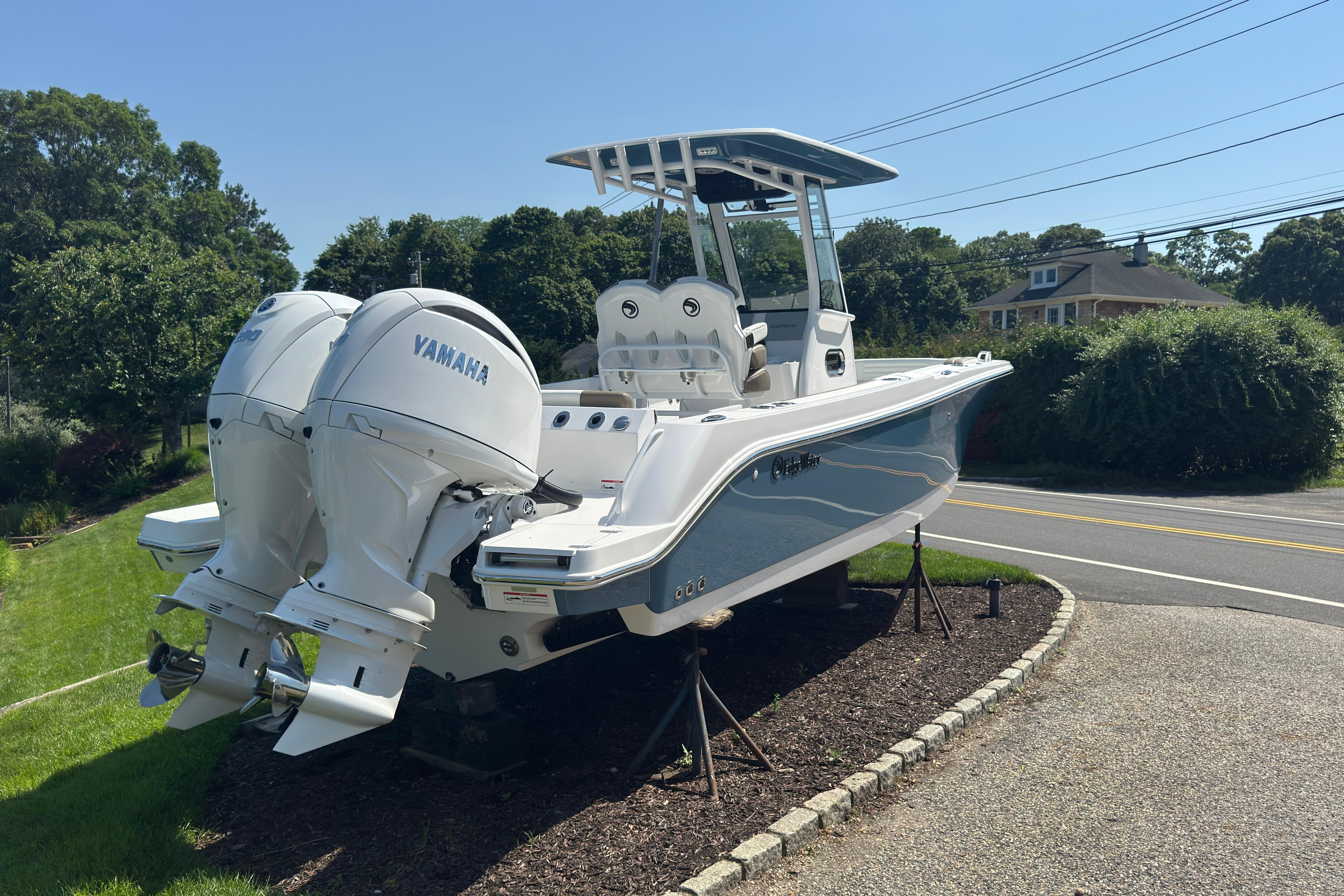 2026 Edgewater 250CC boat with twin Yamaha engines on display outdoors.