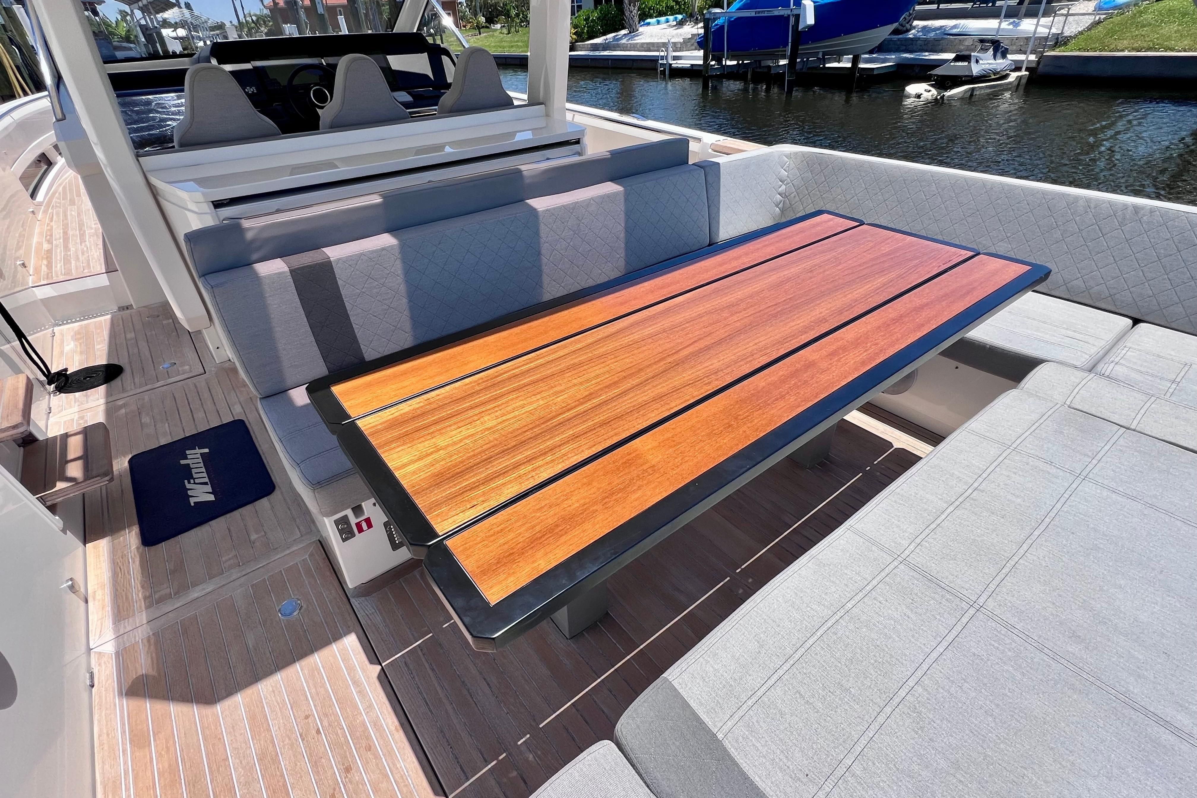 Luxurious seating area on 2022 Windy SR 44 BLACKHAWK yacht with wooden table.