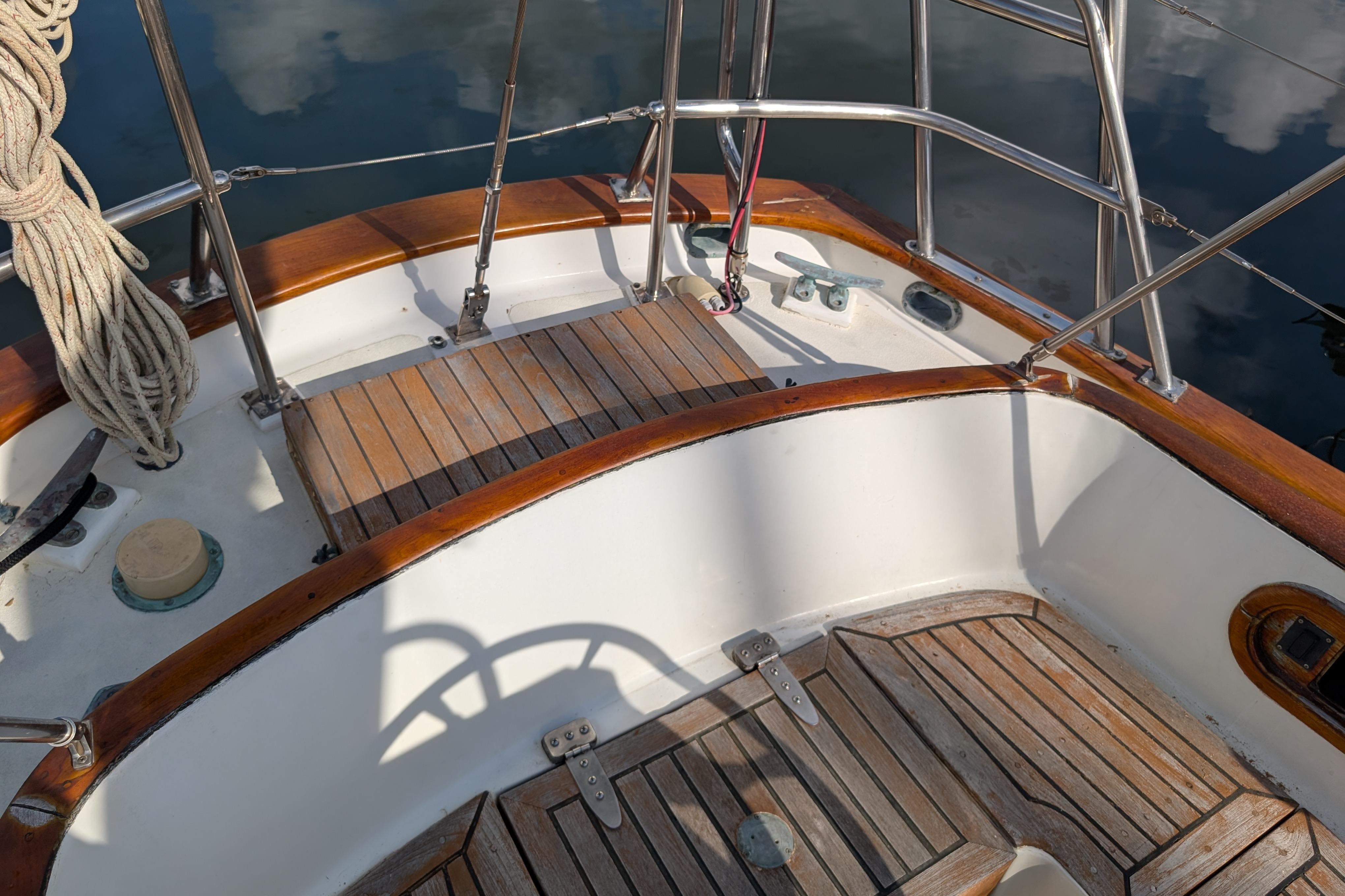 Cockpit of 1983 Robert Perry 41 sailboat with wooden deck and stainless steel railings.