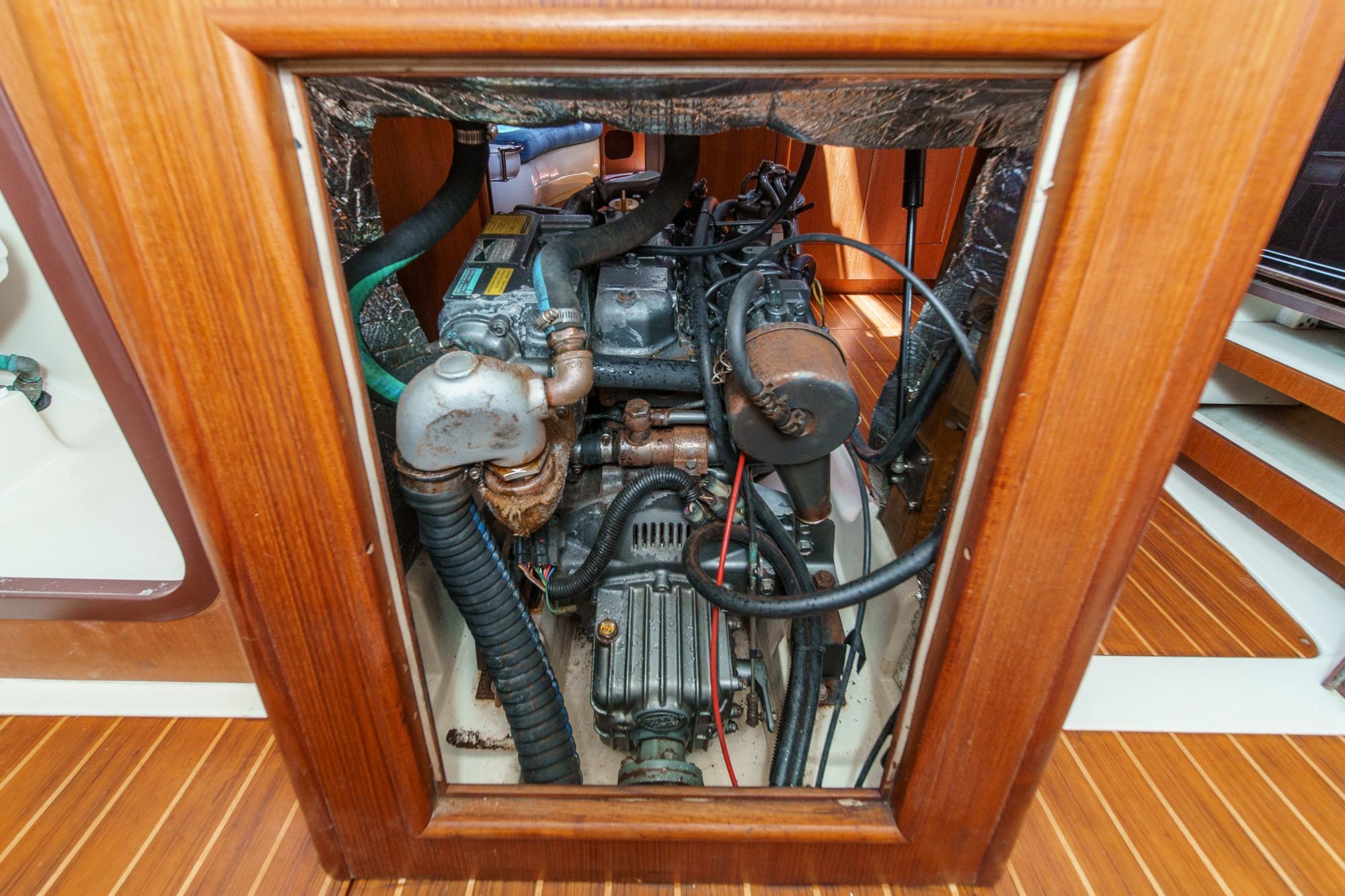 Engine compartment of a 1996 Hunter 376 sailboat, showcasing mechanical components and wooden framing.