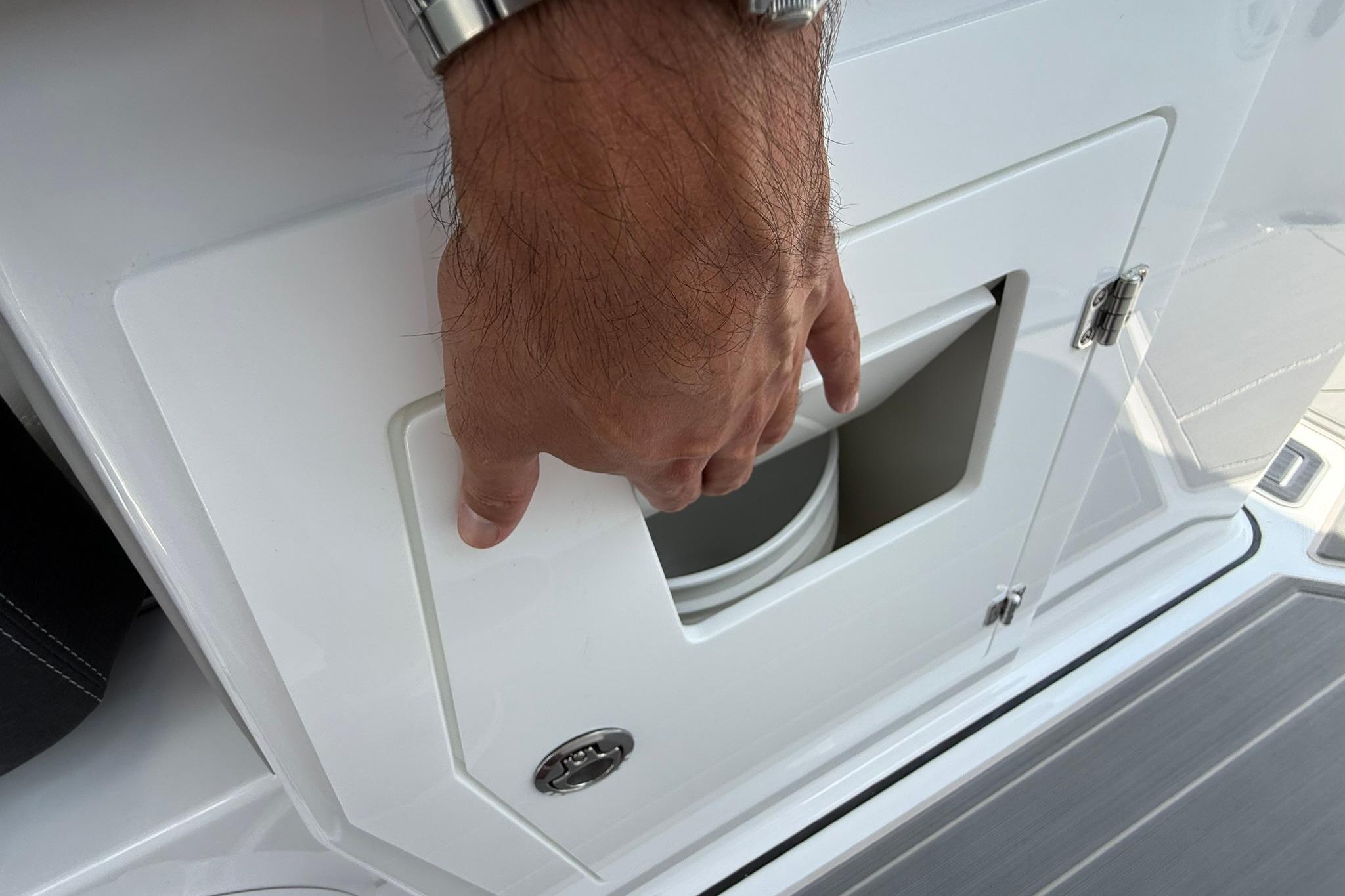 Hand opening storage compartment on 2027 Monterey Elite 30 OB boat.