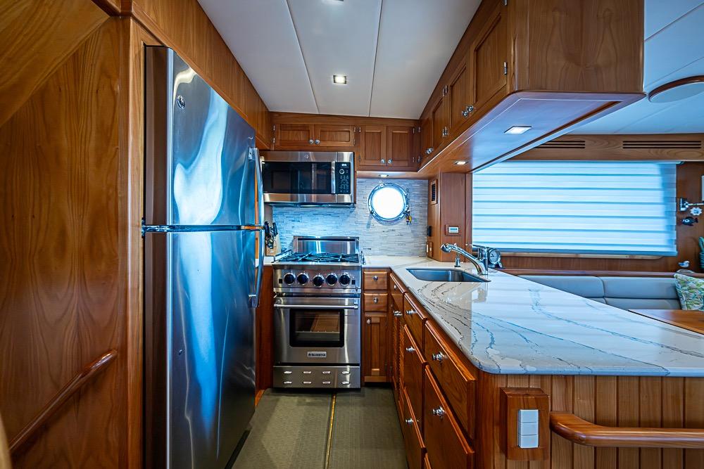 Luxurious 2019 Kadey-Krogen 44 AE yacht kitchen with modern appliances and elegant wood cabinetry.