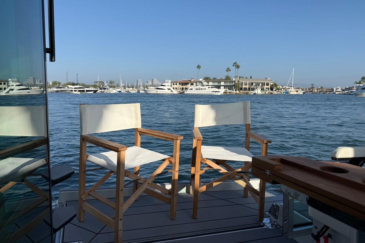 Two chairs on Saxdor 320 GTC yacht deck overlooking marina, 2024 model.