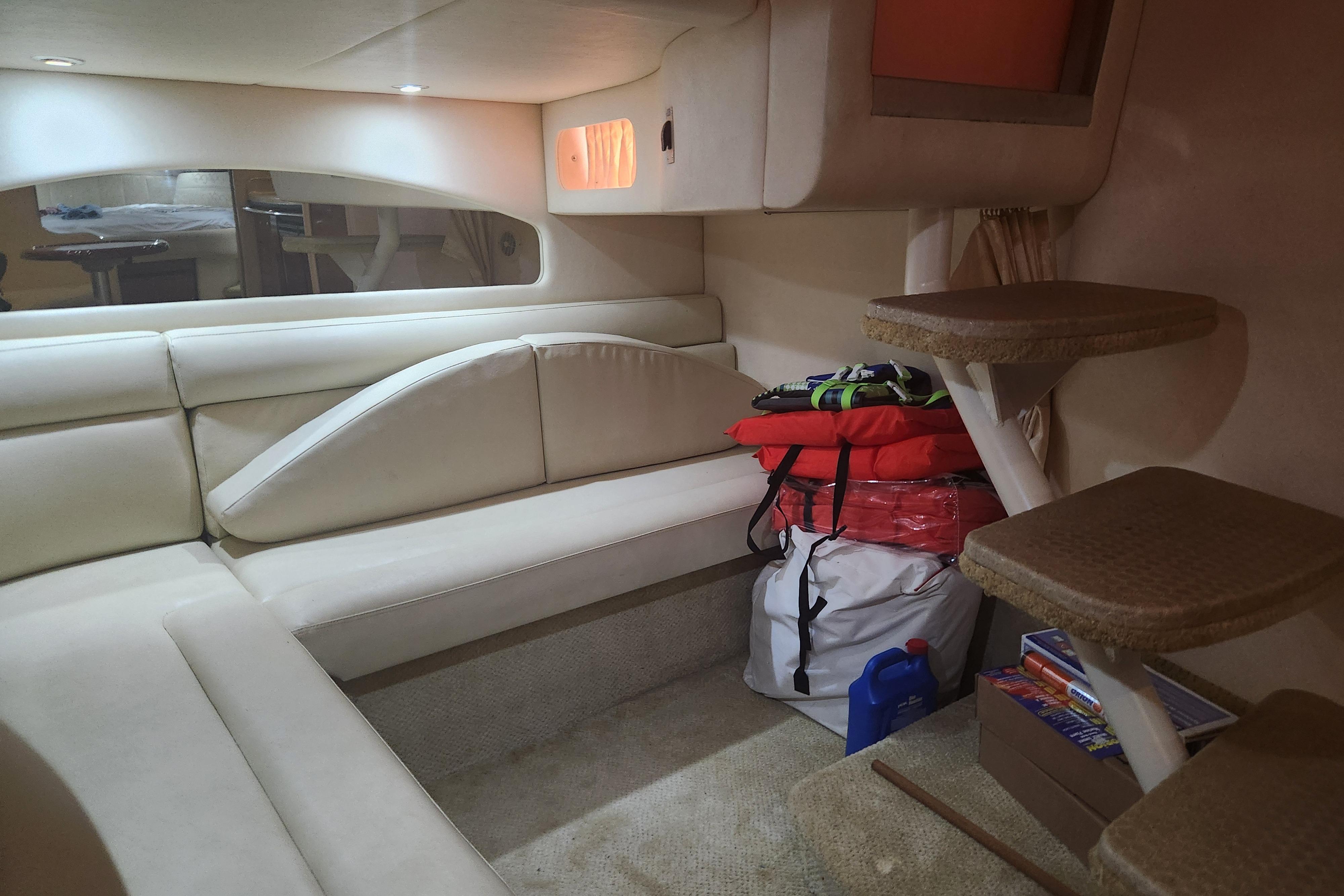 Interior of 2003 Sea Ray 360 Sundancer with beige seating and storage items.