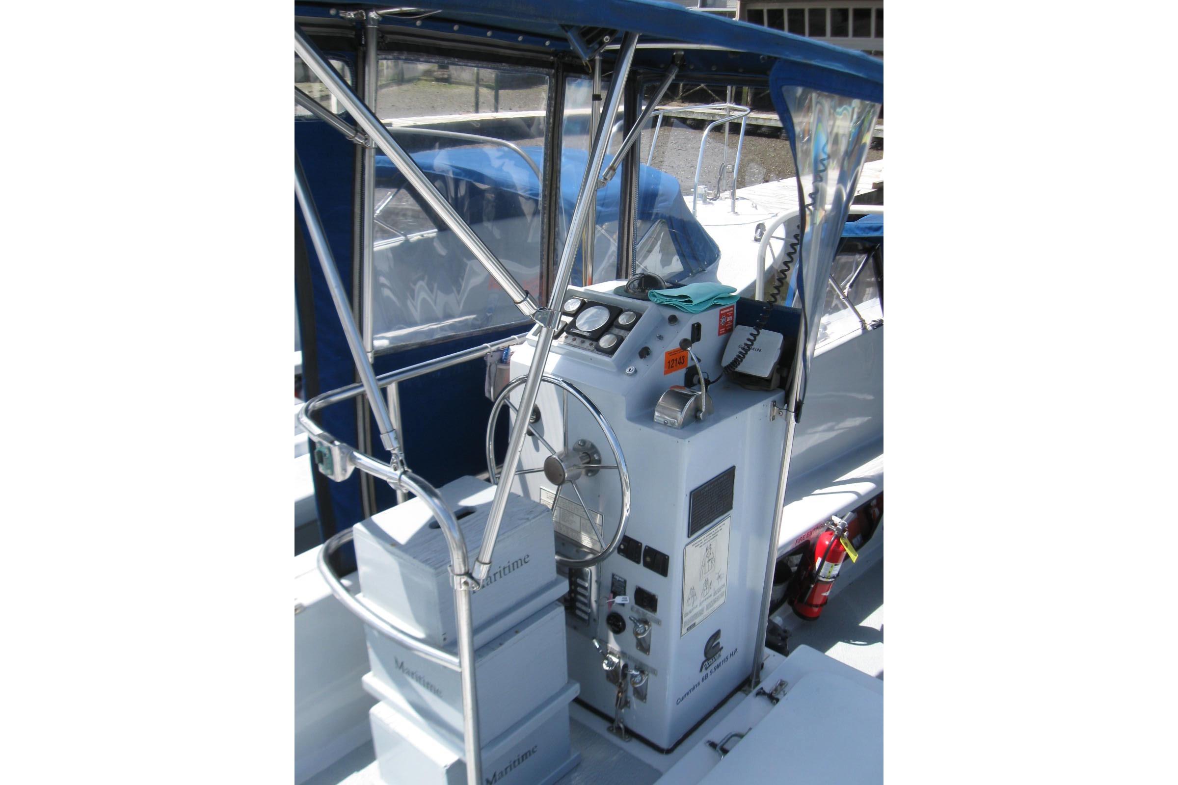 Control console of a 1994 Willard US Navy boat with steering wheel and navigation equipment.