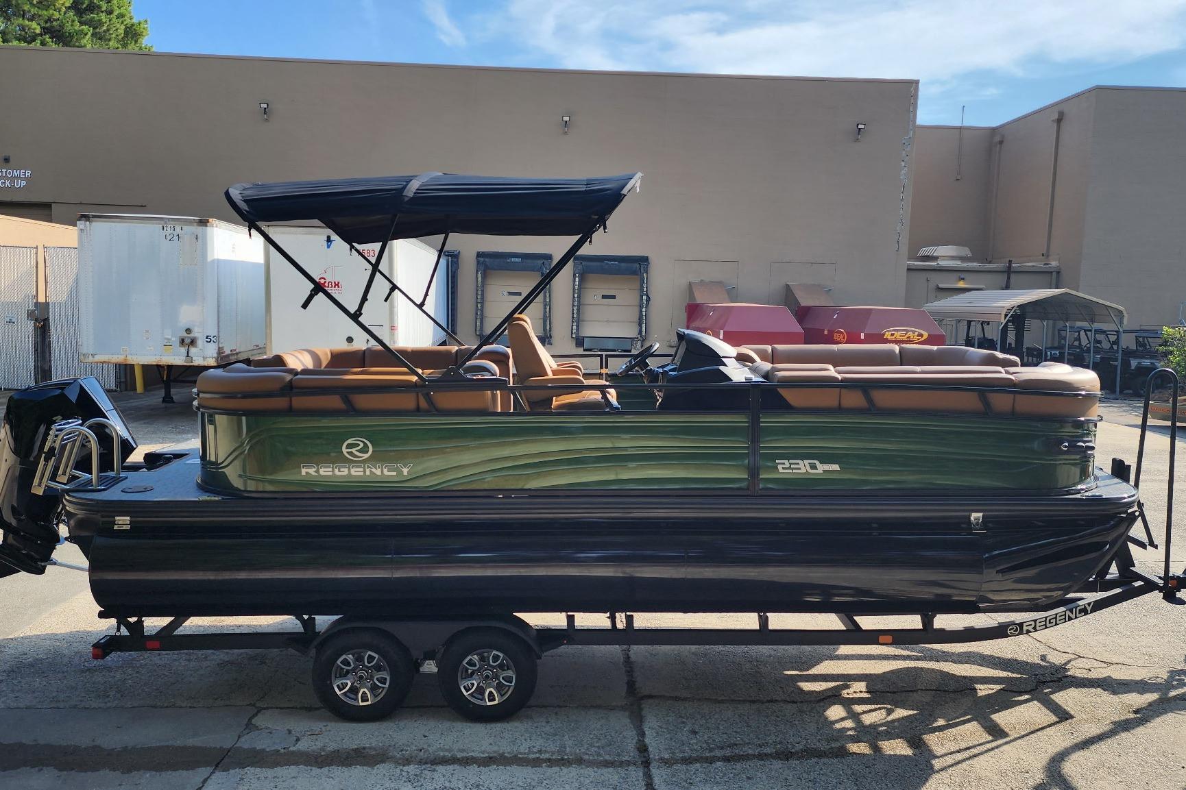 2026 Regency 230 DL pontoon boat on trailer, featuring sleek design and canopy.