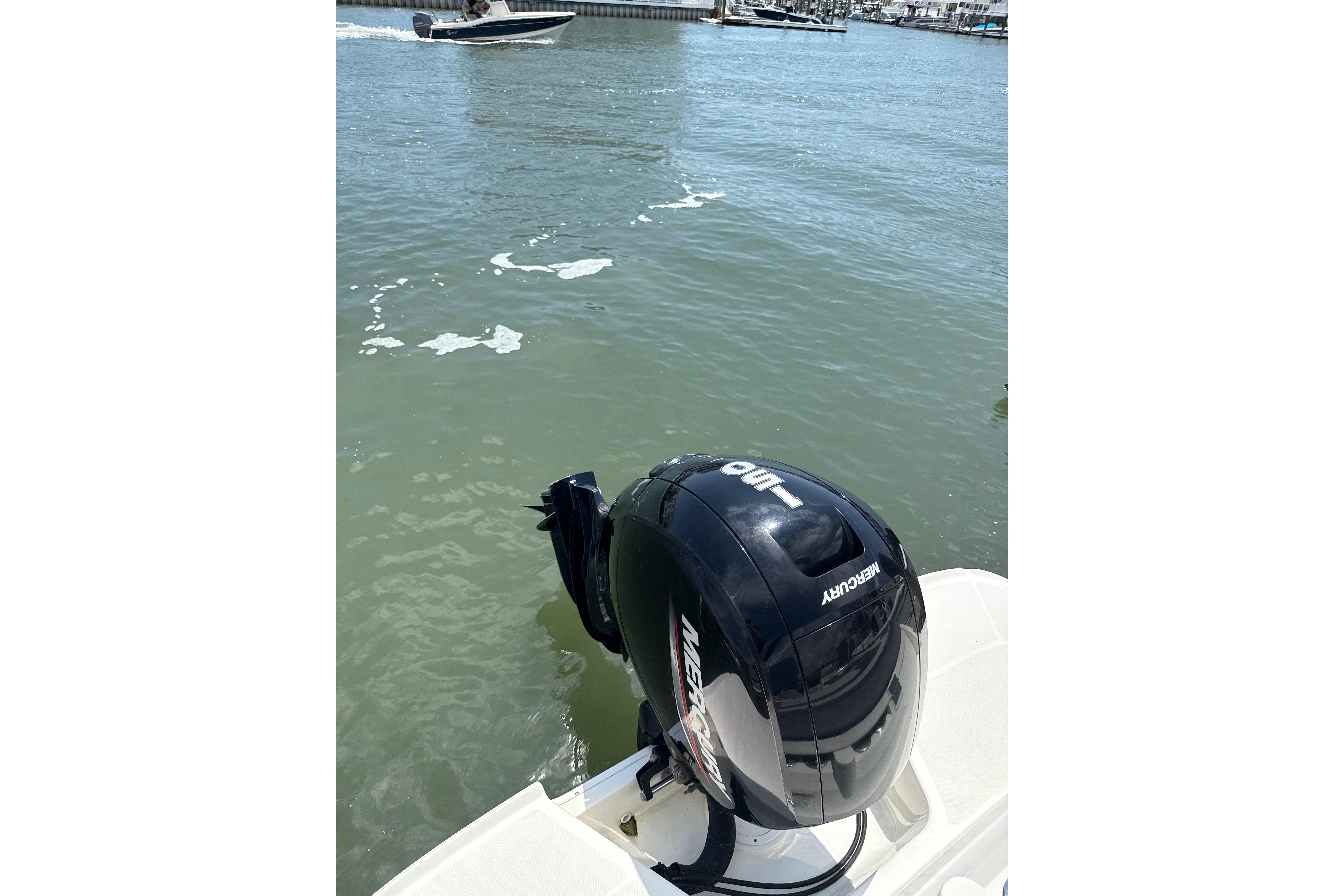 2023 Bayliner VR6 Bowrider OB with Mercury outboard motor on calm water.