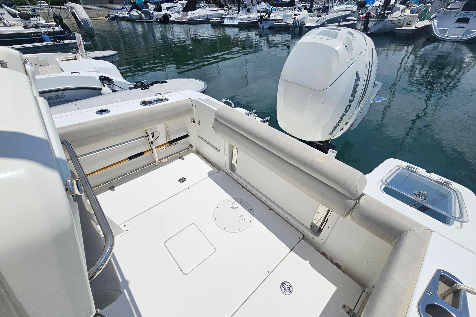 2017 Boston Whaler 230 Outrage boat with Mercury engine, docked in a marina.