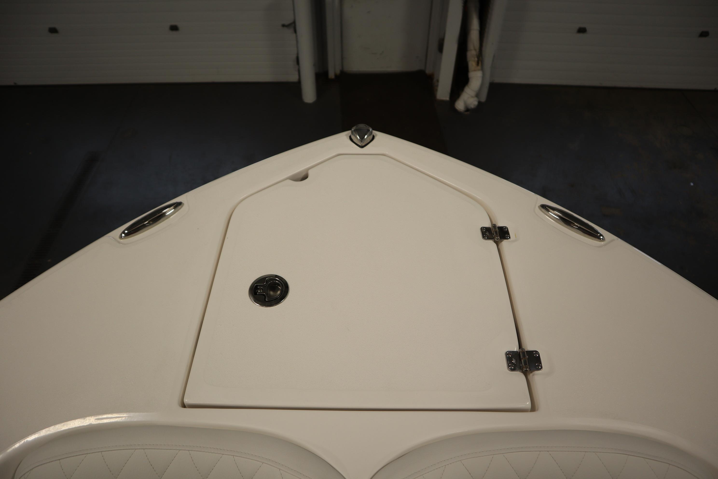 2026 Sea Fox 228 Commander boat deck with storage compartment and stainless steel fixtures.