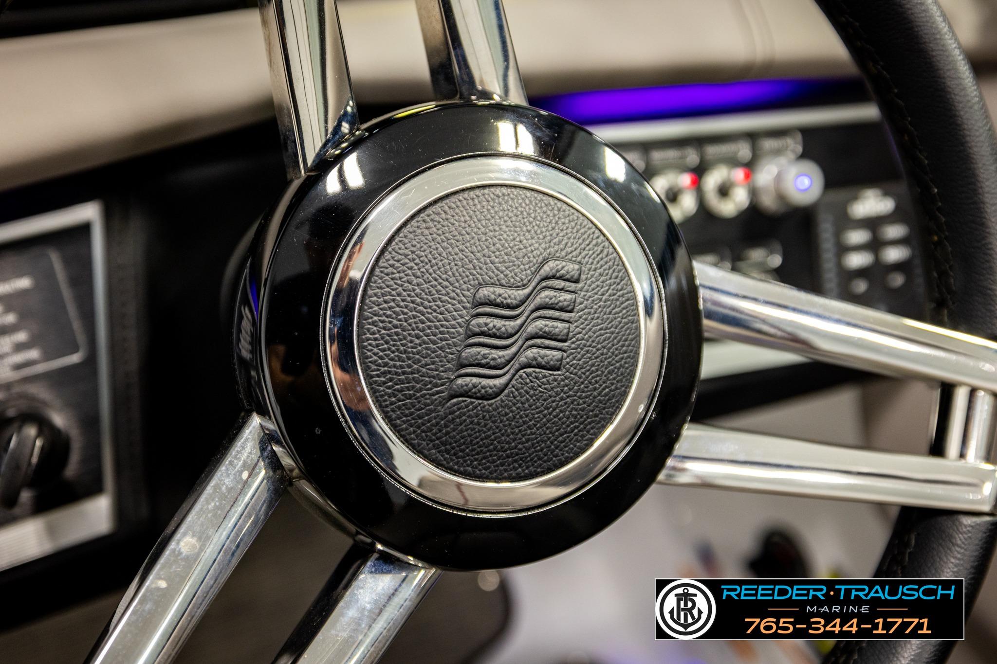 Steering wheel of 2024 FOURWINNS HD5 Surf boat, featuring sleek chrome design.