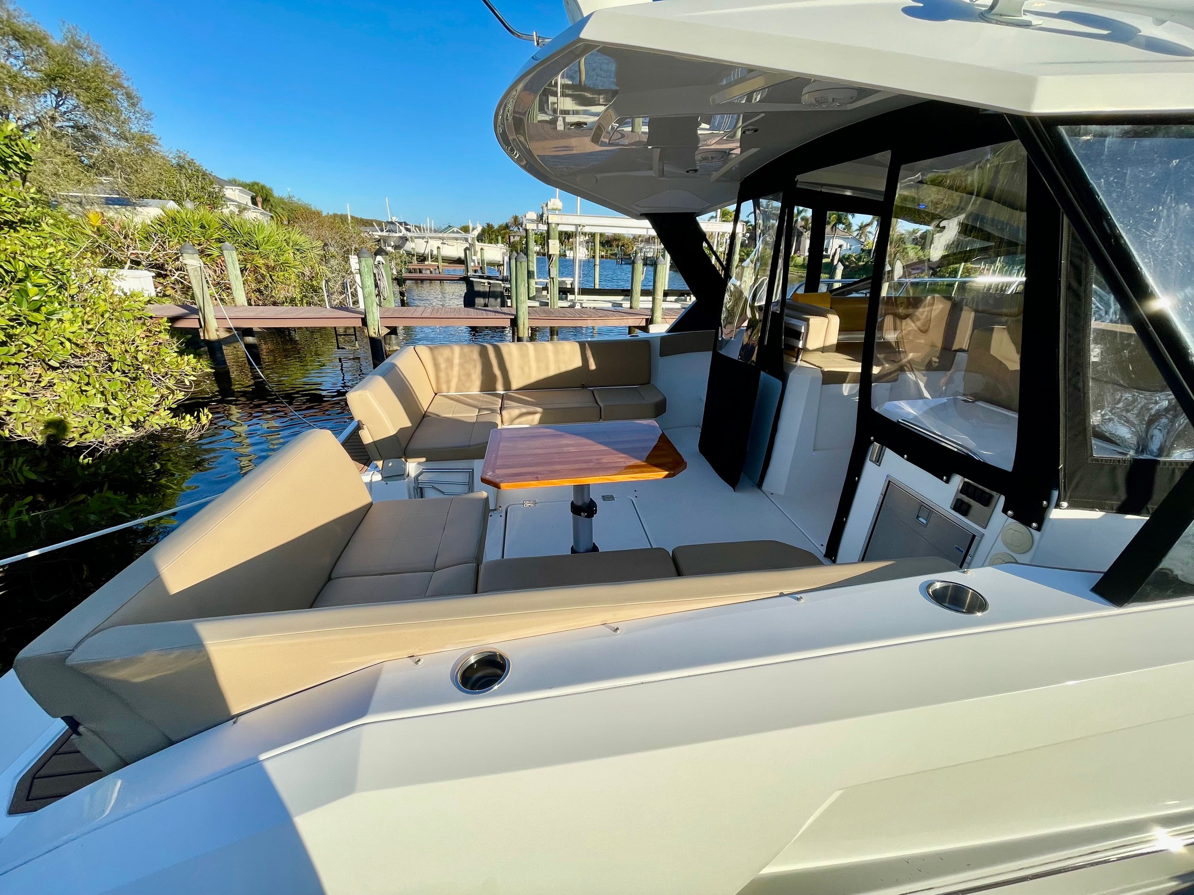 The image shows the cockpit of a 2016 Cruisers Yachts 390 Express Coupe with beige seating.