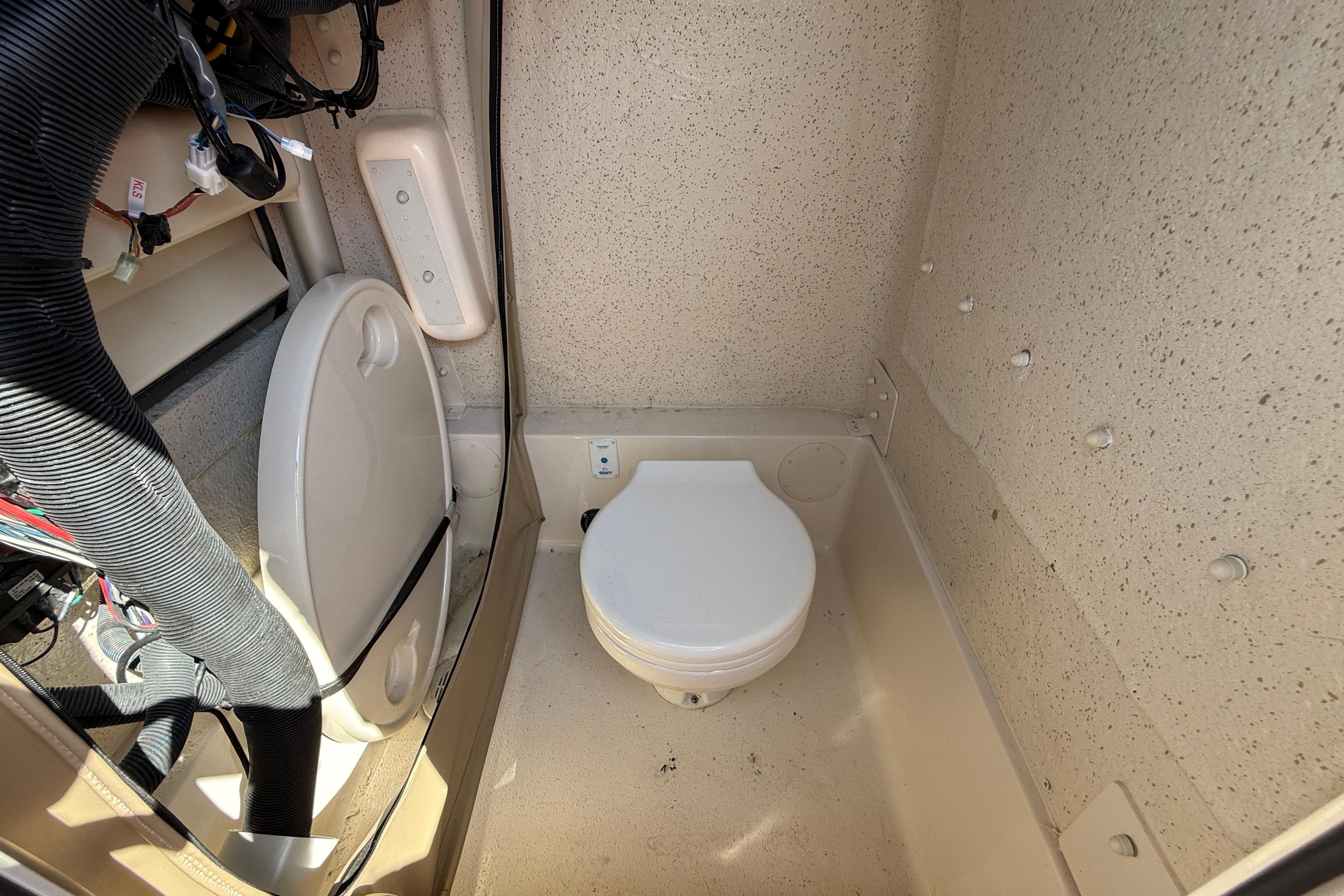 2023 SeaChaser 24 HFC boat interior with compact marine toilet.