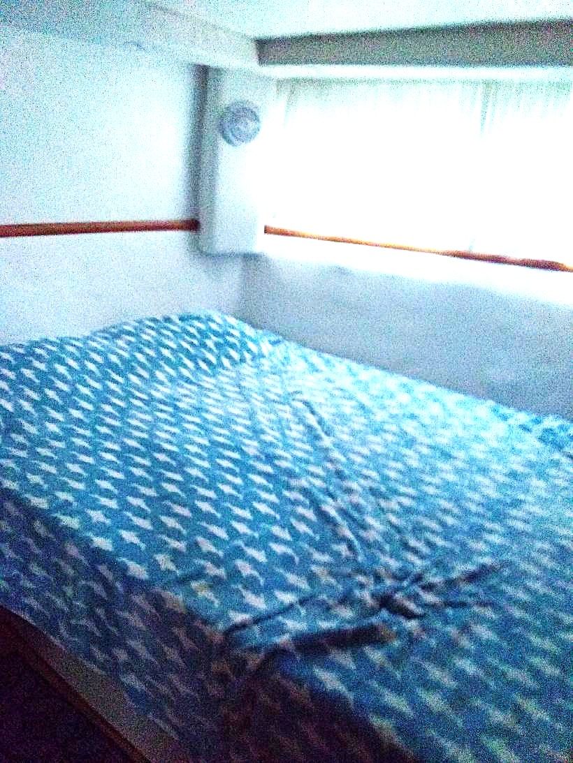 Interior of a 1995 Carver 35 with a bed and blue bedding.