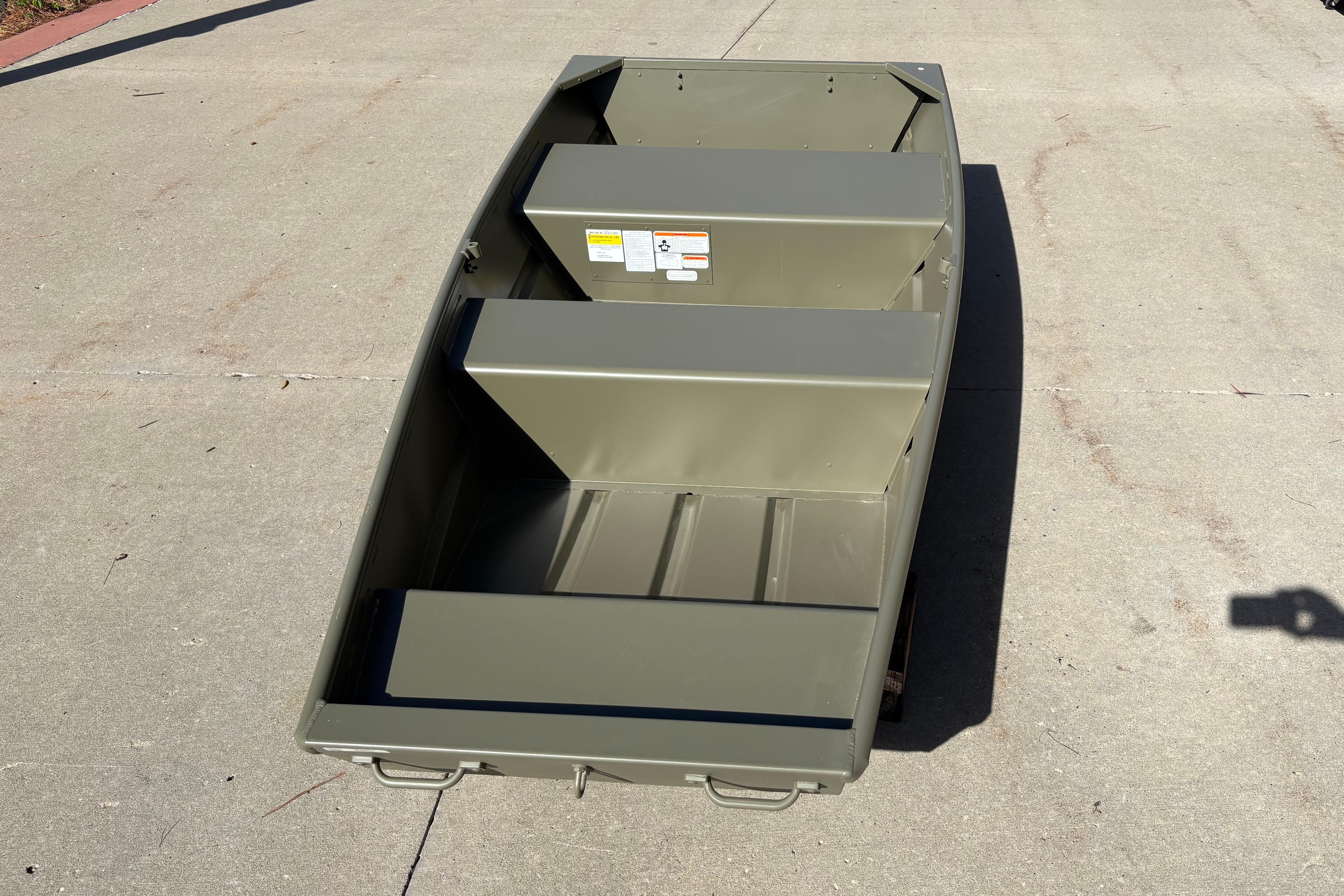 2026 Tracker Grizzly 10 Jon boat on concrete surface, showcasing interior seating and structure.