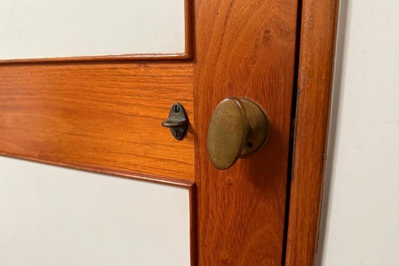 Wooden door detail with brass handle on 1993 Brooklin Boat Yard Marshall 48.
