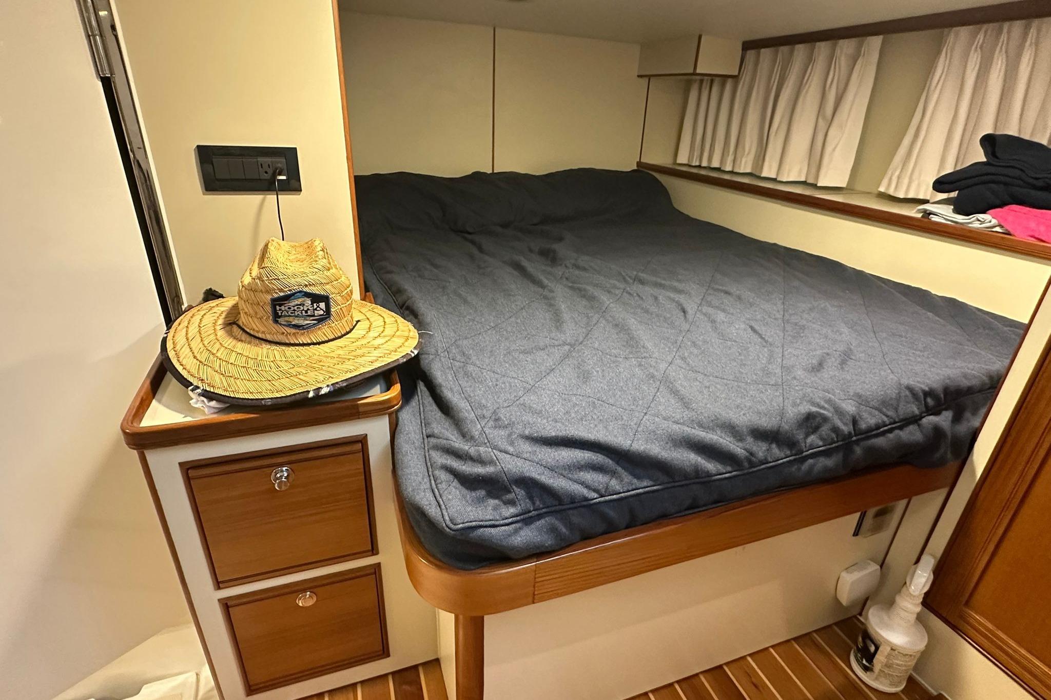 Cozy cabin interior of 2023 Marlow Explorer 66E-CB with bed and straw hat.